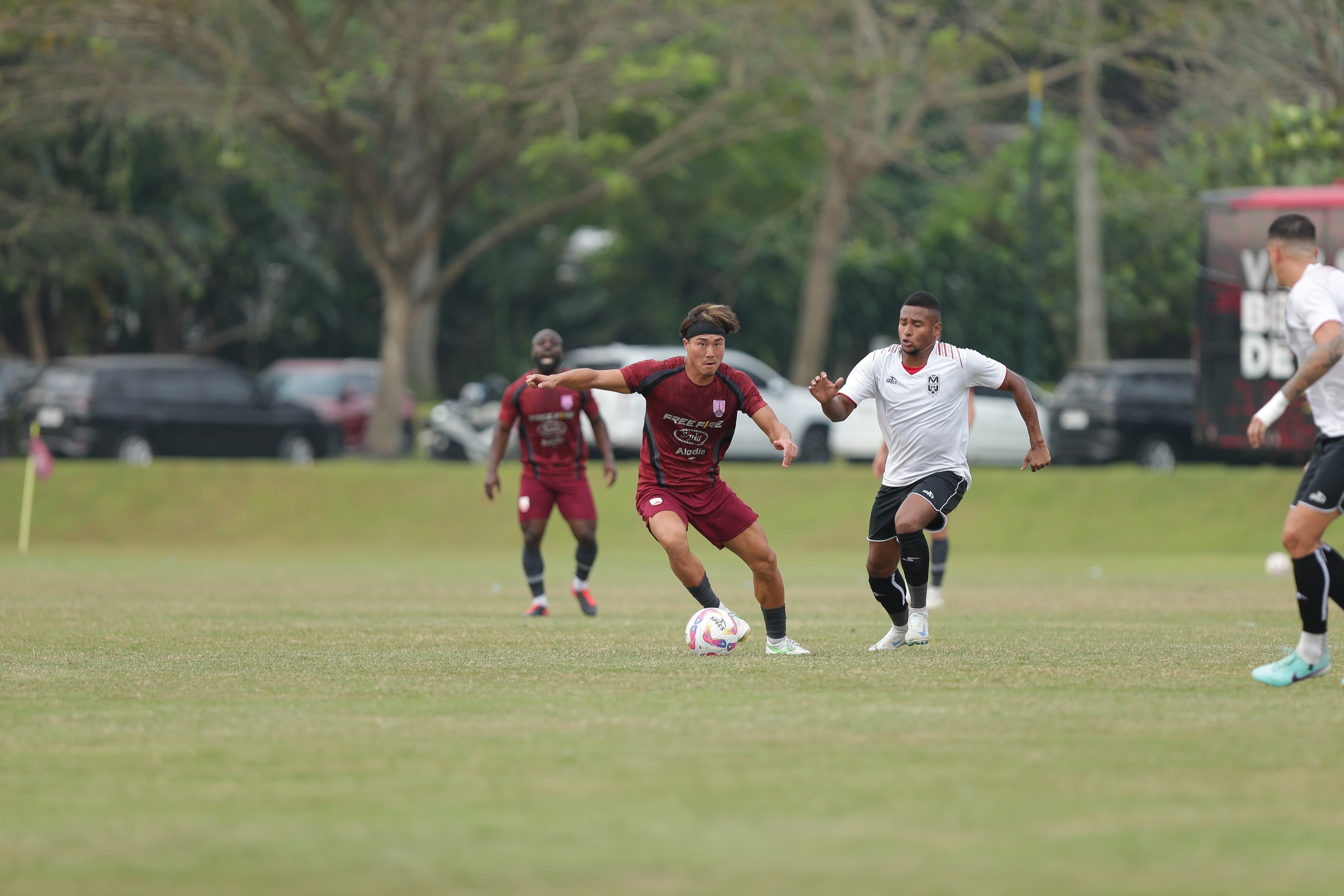 Bomber anyar Persis Solo asal Jepang Kodai Tanaka dikawal pemain Malut United dalam ekshibisi di Lapangan Yogyakarta Independent School (YIS), Rabu sore (23/7).