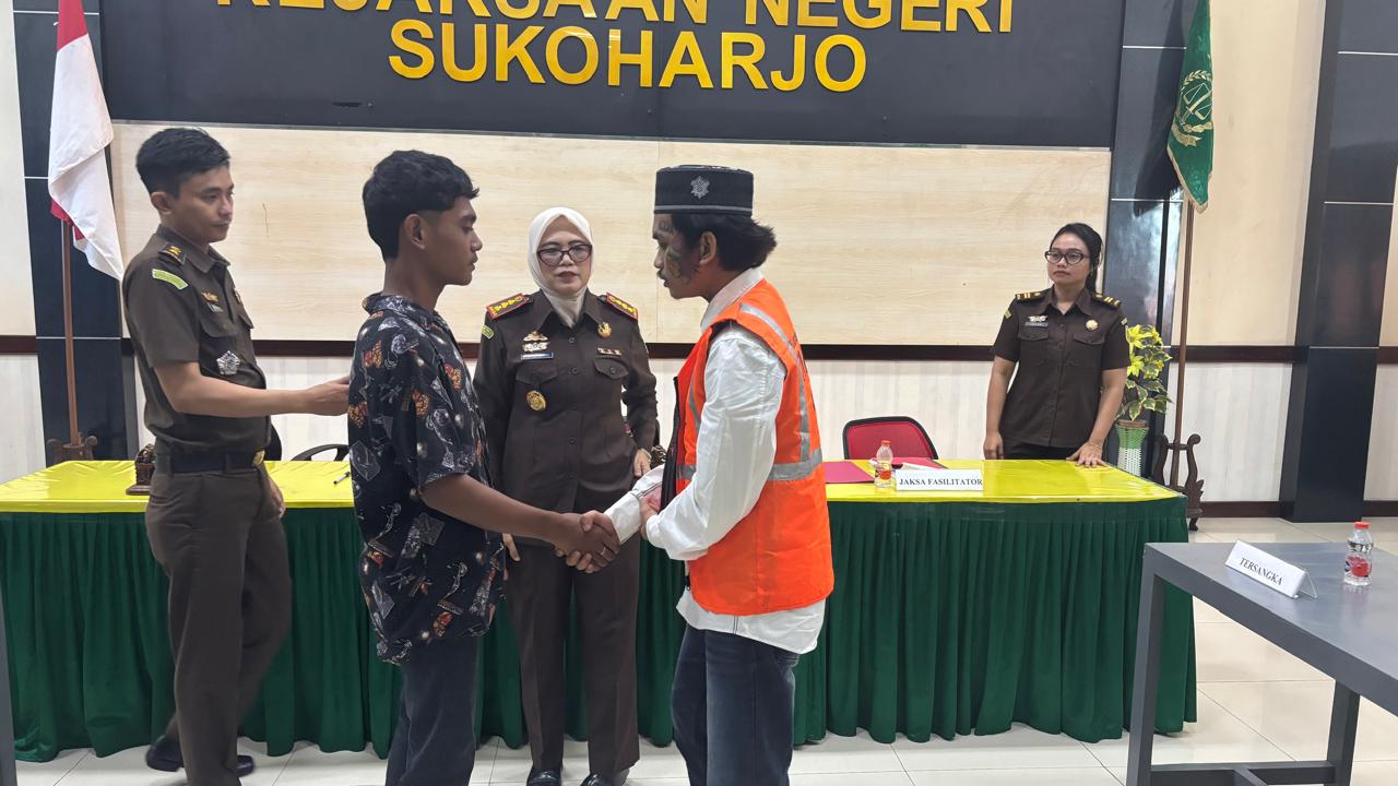 Pelaku penganiayaan R (kanan) bersalaman dengan korban J di kantor Kejaksaan Negeri Sukoharjo, Rabu (23/7).