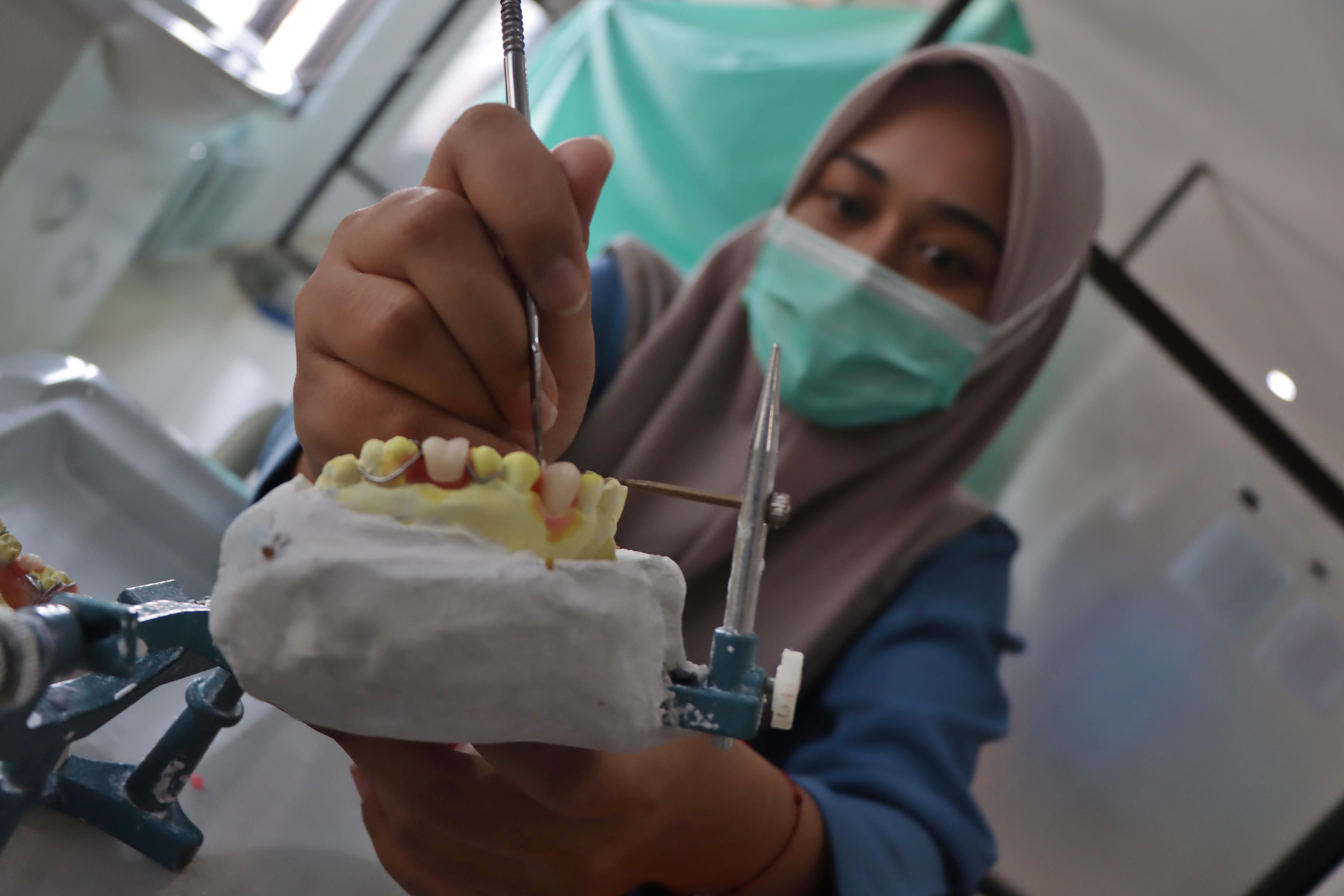 Mahasiswa koas berlatih membuat gigi palsu alias prosthodonti saat menjalani praktik kerja di Rumah Sakit Gigi dan Mulut (RSGM) Soelastri Solo, Senin (28/7).