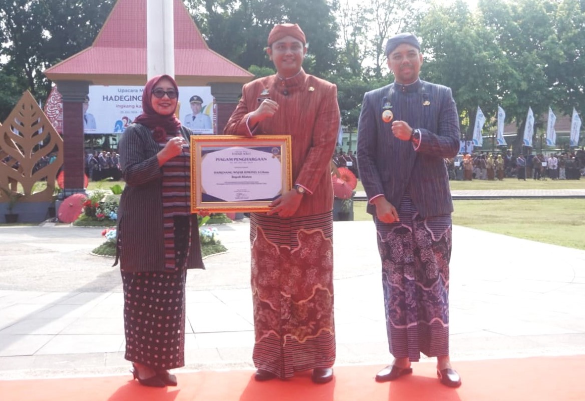 Direktur Jawa Pos Radar Solo Resita Rika Aryani serahkan penghargaan kepada Bupati Klaten Hamenang Wajar Ismoyo di Alun-alun Klaten, Senin (28/7/2025).