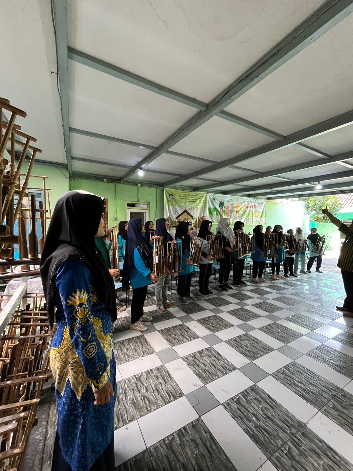 Memainkan alat tradisional angklung.