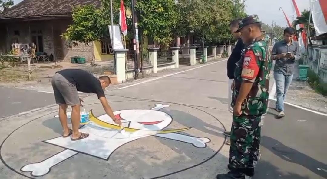 Aparat mengawasi penghapusan mural bergambar anime One Piece di Karangmalang, Sragen, Minggu (3/8/2025).