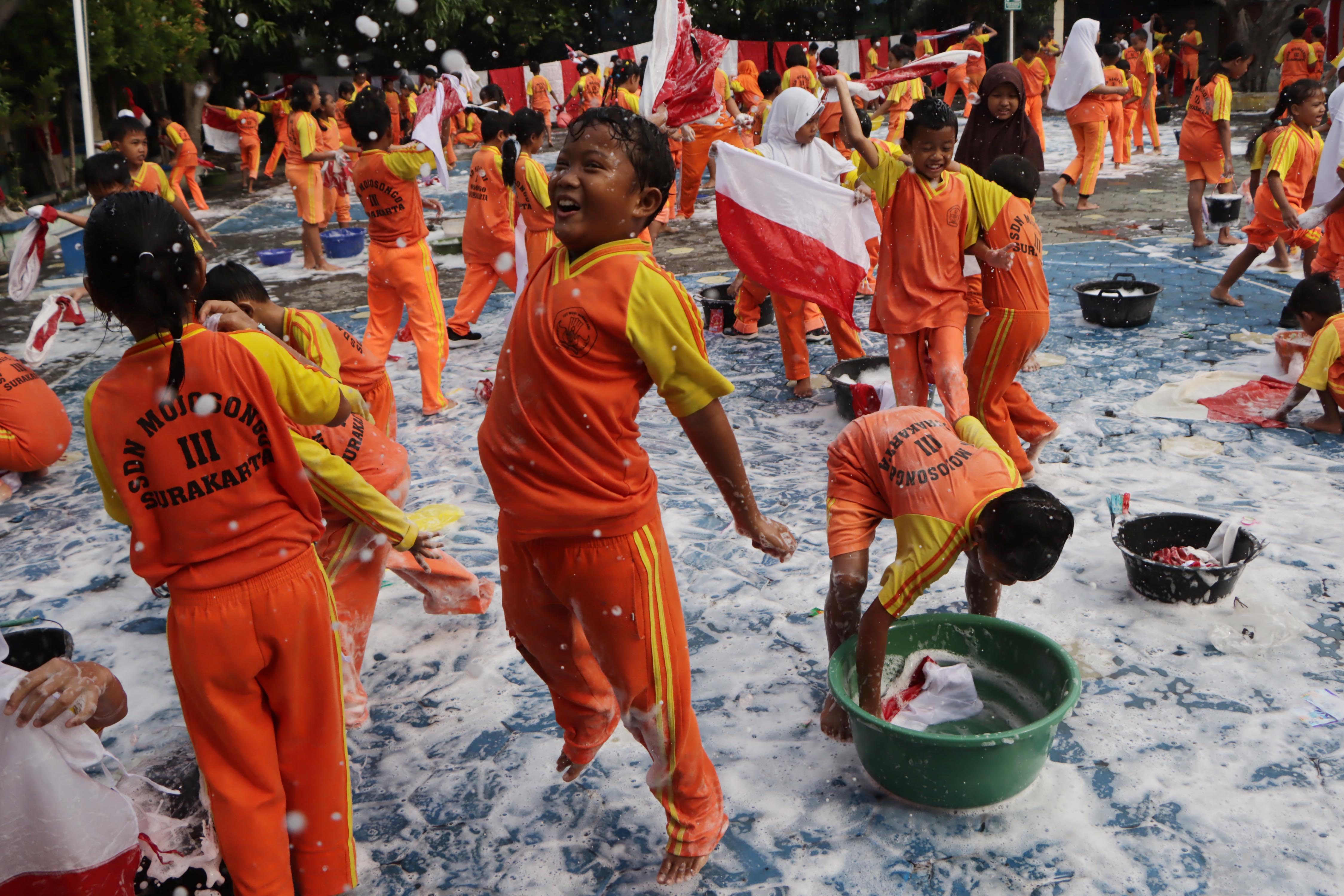 Raut keceriaan para siswa SD Mojosongo III saat mencuci bendera merah putih di halaman sekolah setempat, Selasa pagi (5/8).