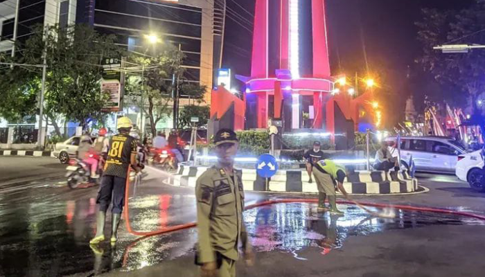 Petugas Damkar Sukoharjo dibantu tim gabungan memberihkan tumpahan solar di sekitar Simpang Lima Sukoharjo, yang akibatkan puluhan kendaraan alami kecelakaan, Selasa (5/8/2025).