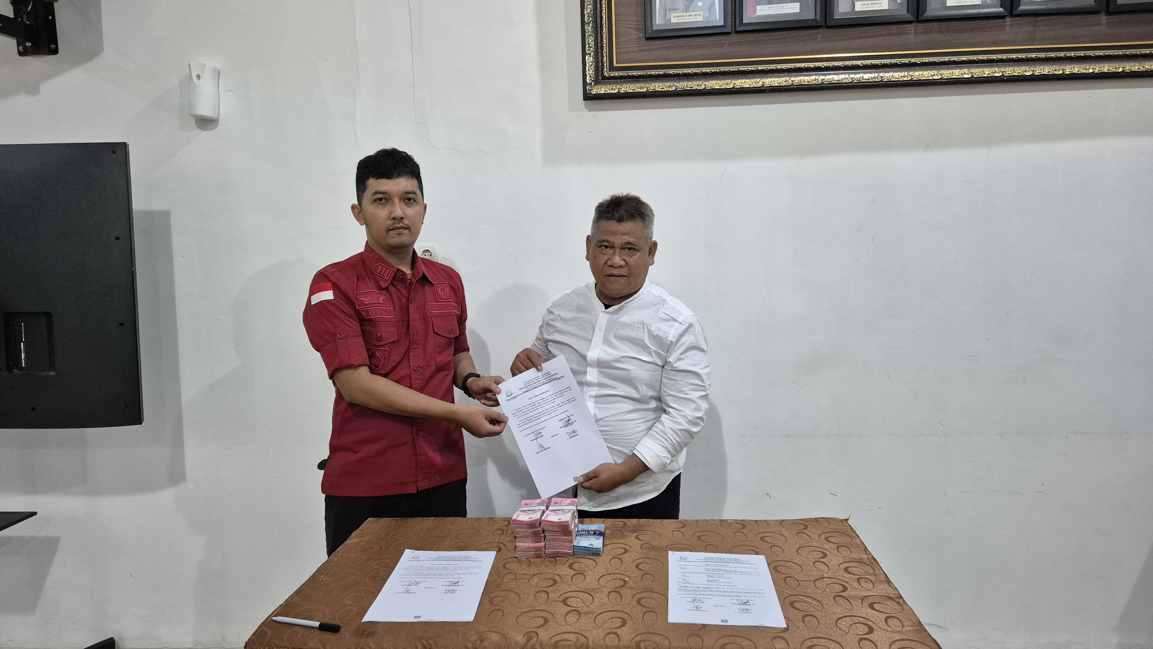 Sekretaris Dispermades Karanganyar nonaktif Sunarto (kanan) menyerahkan uang Rp 105 juta terkait statusnya sebagai tersangka dugaan korupsi pembangunan Masjid Agung Madaniyah ke kejari. (Ist)