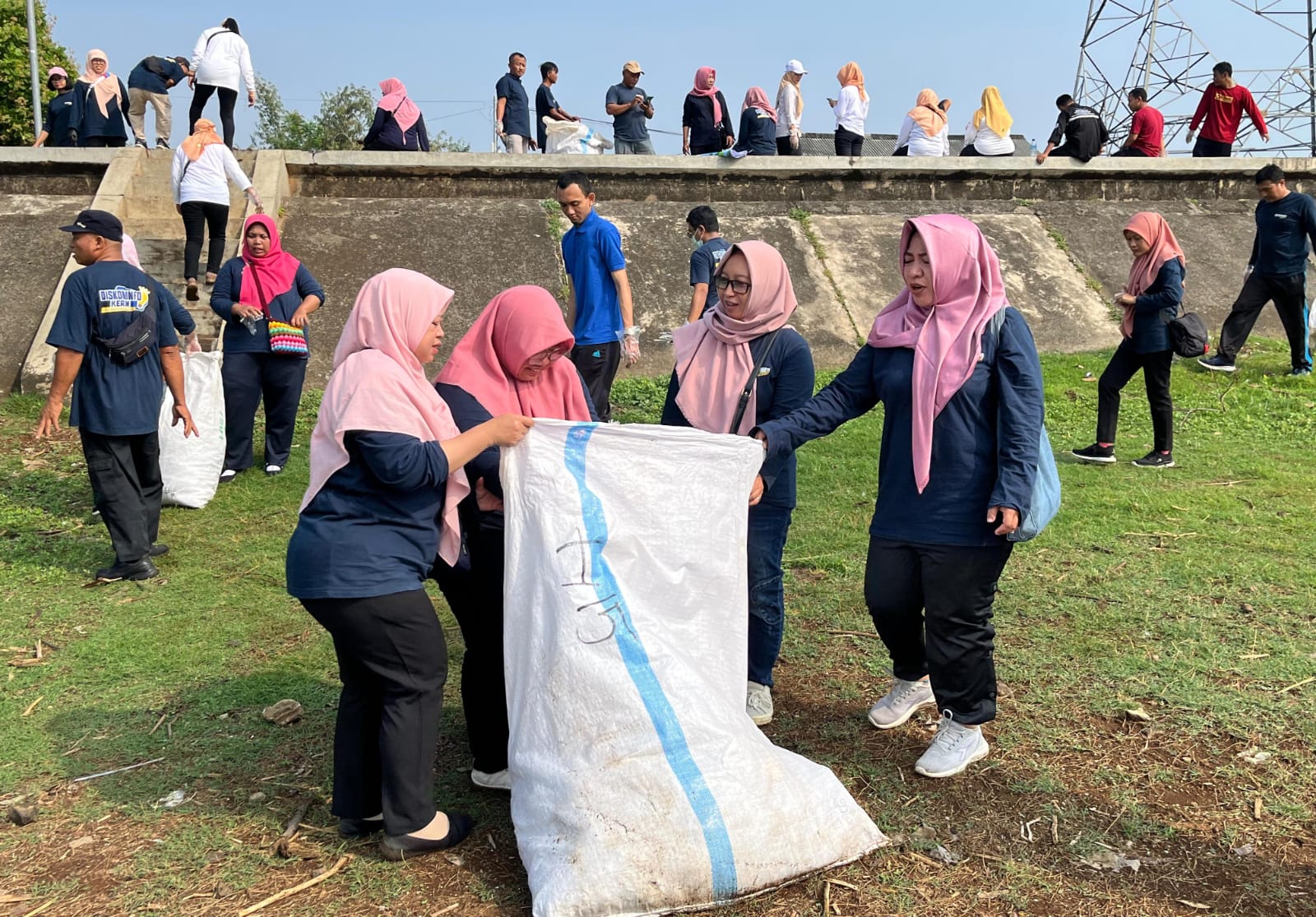 Pegawai Diskominfo Karanganyar bersihkan sampah di area Waduk Delingan Karanganyar, Jumat (8/8/2025). (Rudi Hartono/Radar Solo)