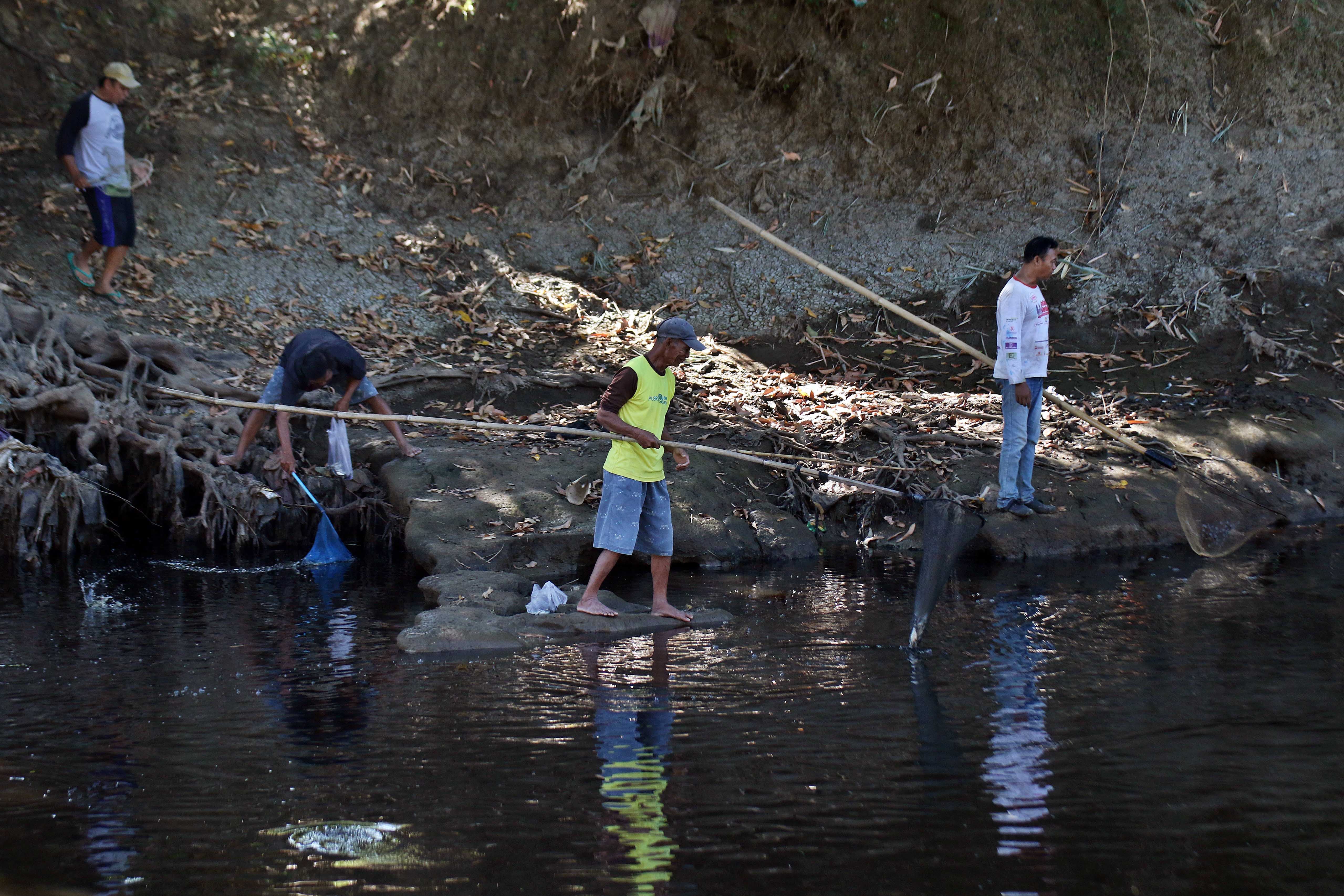 Warga menjaring ikan di Kali Samin, Desa Kadokan, Kecamatan Grogol, Kabupaten Sukoharjo yang airnya tercemar limbah, belum lama ini.