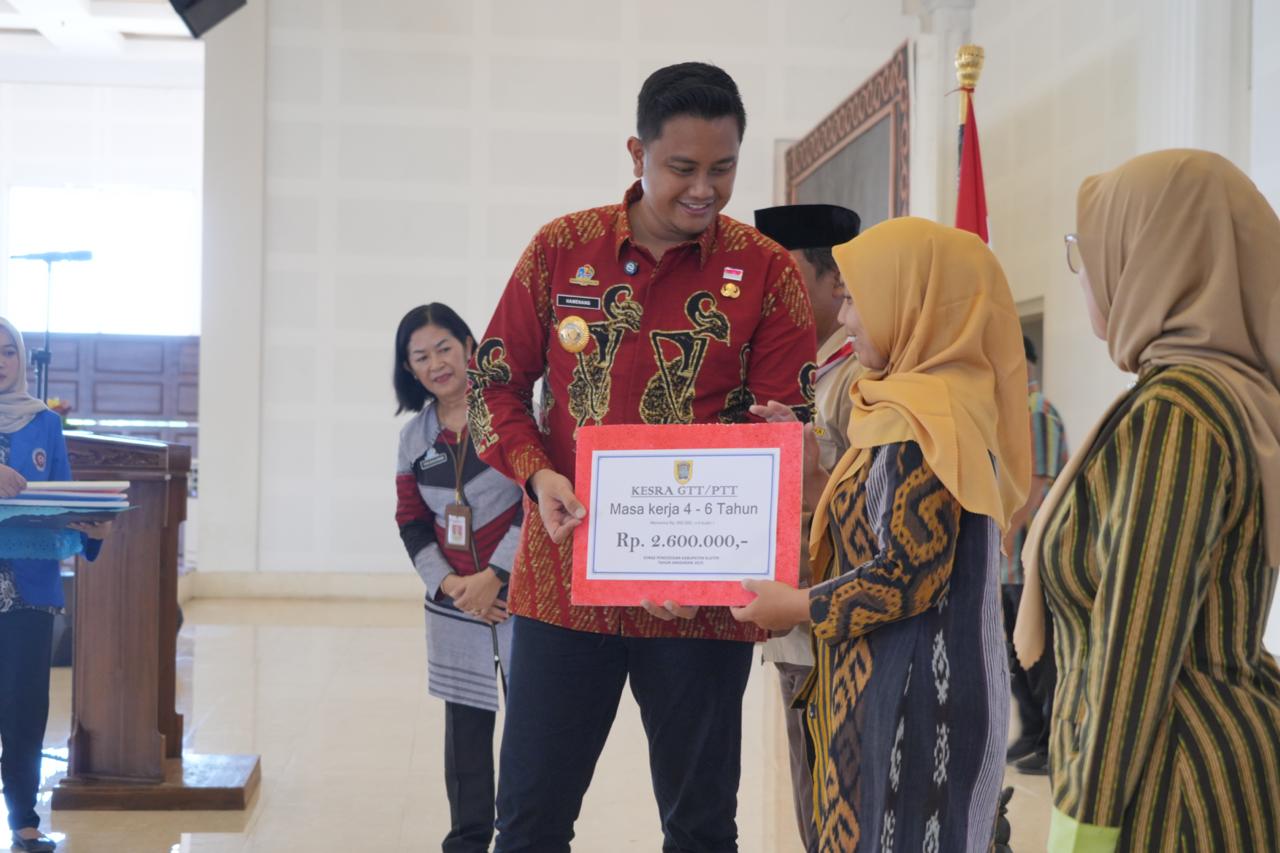 Bupati Klaten Hamenang Wajar Ismoyo menyerahkan tunjangan terhadap perwakilan GTT dan PTT, Kamis (14/8/2025). (Angga Purenda/Radar Solo)