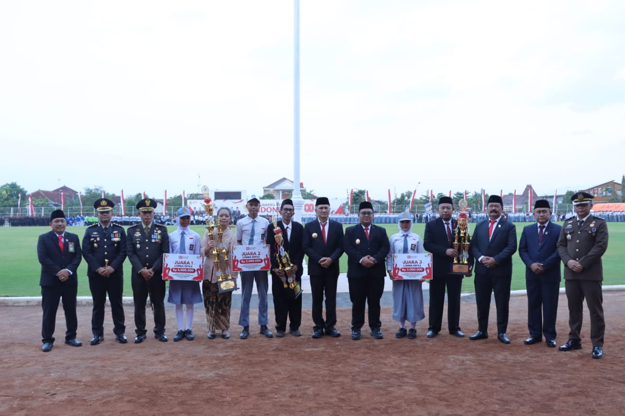 Pemenang loma defile bersama Bupati-Wabup Wonogiri Setyo Sukarno-Imron Rizkyano dan unsur Forkopimda di sela upacara Parade Senja penurunan bendera di Stadion Pringgodani, Minggu (17/8/2025).