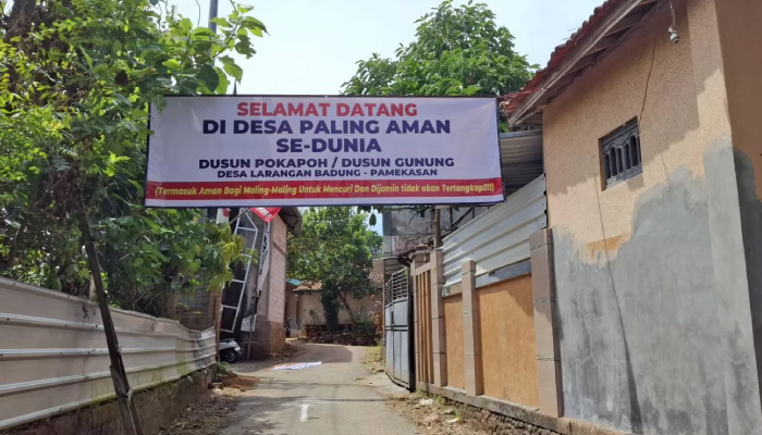 Spanduk bernada satir terpasang di salah satu sudut di Dusun Pokapoh, Desa Larangan Badung, Kecamatan Palengaan, Pamekasan, Madura.