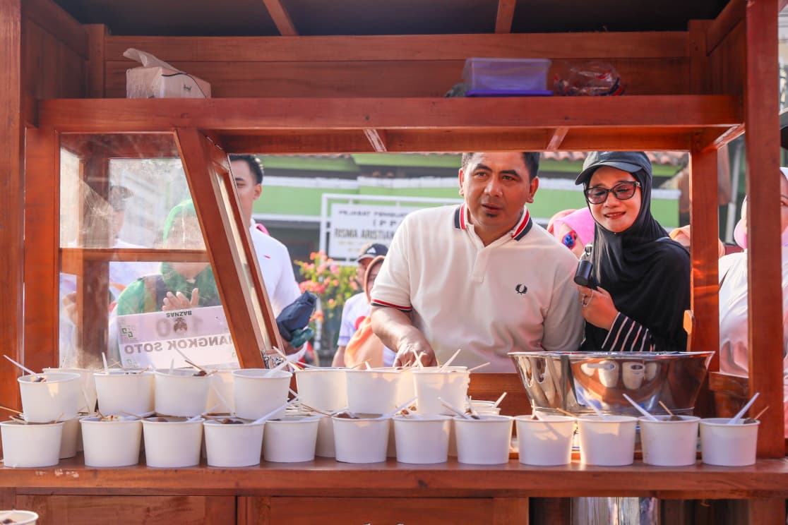 Taj Yasin dan istri memesan soto di sela jalan sehat.
