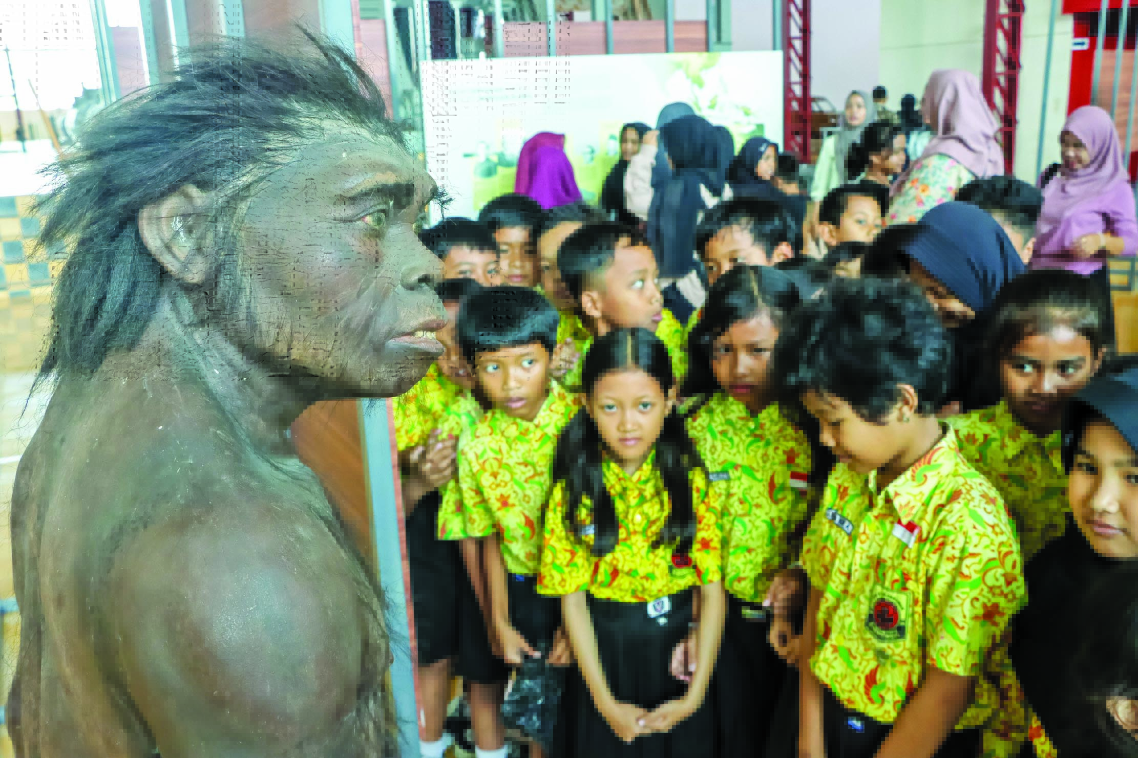 Sejumlah siswa SD melihat replika manusia purba dalam pameran yang digelar Museum Manusia Purba Sangiran di Museum De Tjolomadoe, Colomadu, Karanganyar, Kamis (28/8).