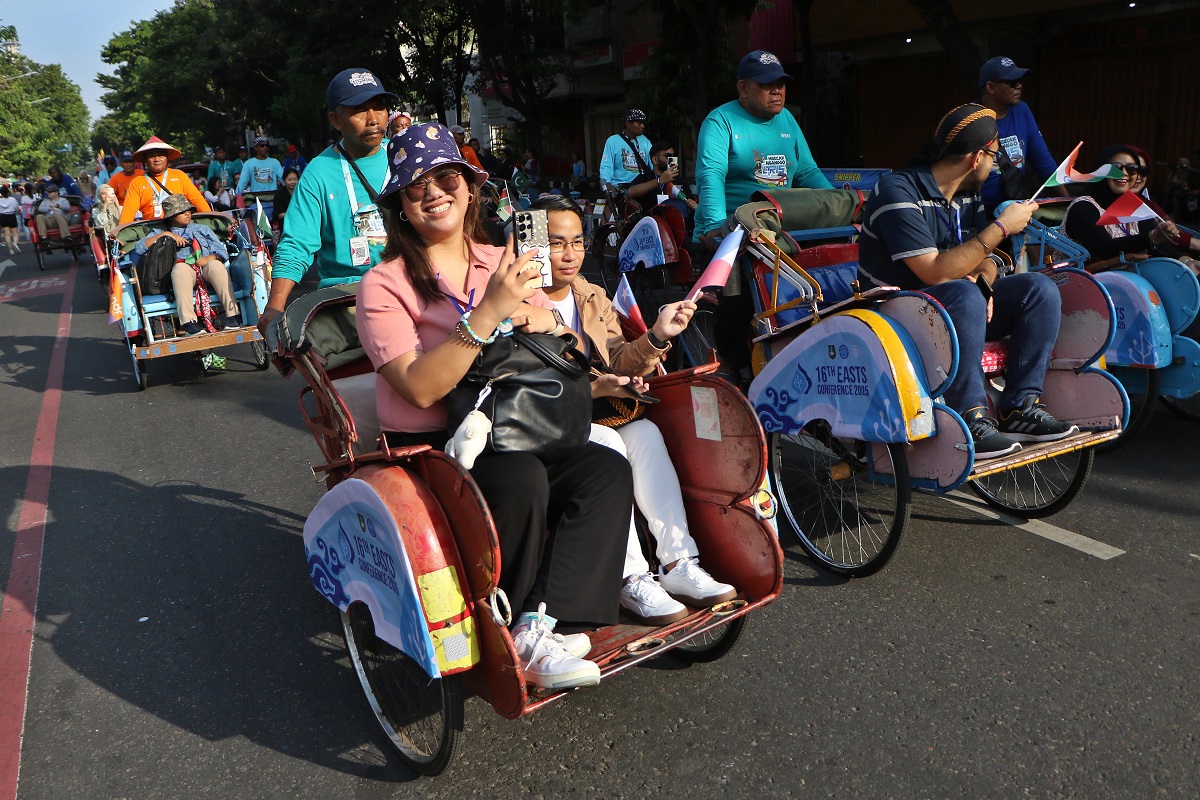 Delegasi The 16th EASTS Conference melintasi kawasan CFD Jalan Slamet Riyadi dengan mengendarai becak, Minggu (31/8/2025).