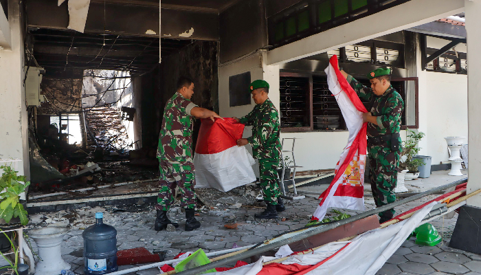Personel TNI ikut kerja bakti membersihkan sisa-sisa kebakaran di gedung DPRD Solo, Minggu (31/8/2025).