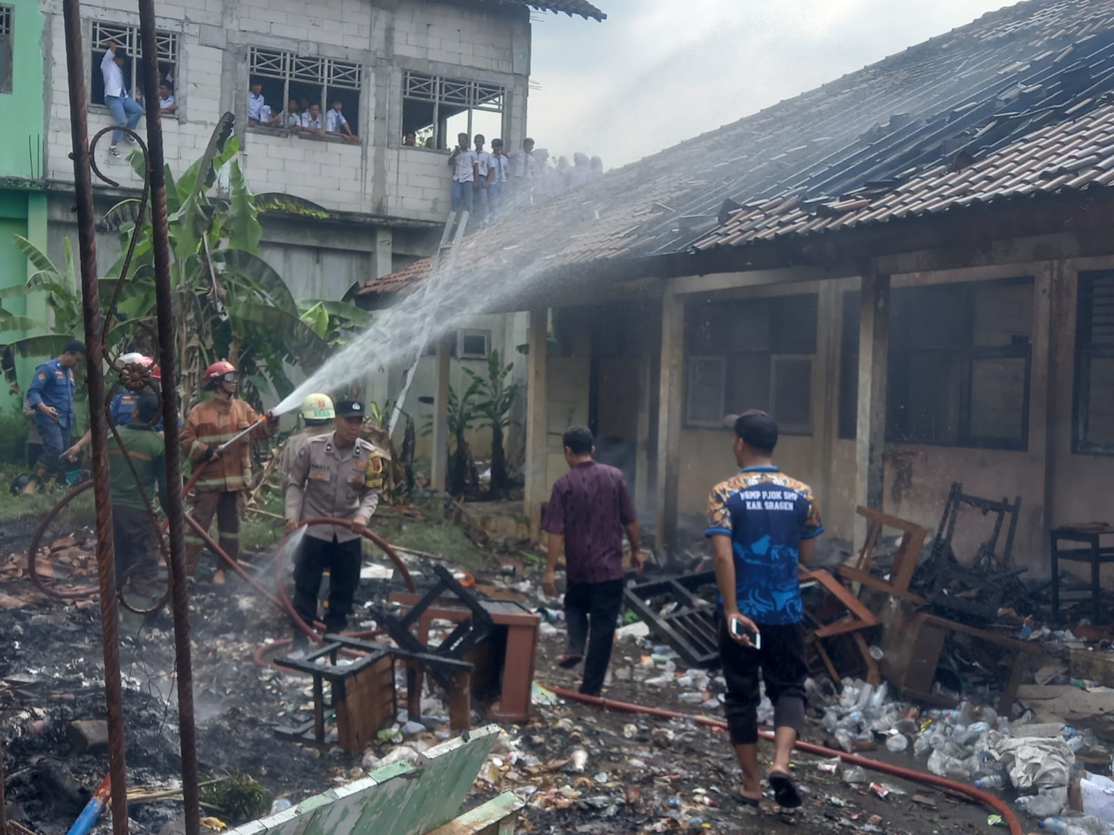 Tim damkar berupaya memadamkan api di gudang bekas SMPN 1 Sambirejo, Sragen, Senin (1/9/2025). (Ahmad Khairudin/Radar Solo)
