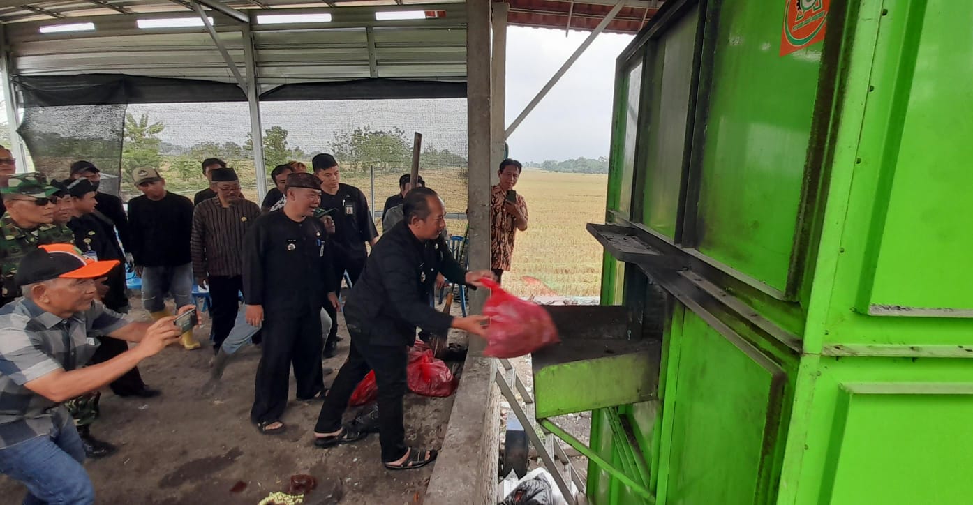 Bupati Karanganyar Rober Christanto saat mencoba menikmati oksidator sampah yang dibuat oleh pemerintah desa Papahan.  (Rudi Hartono/Radar Solo)