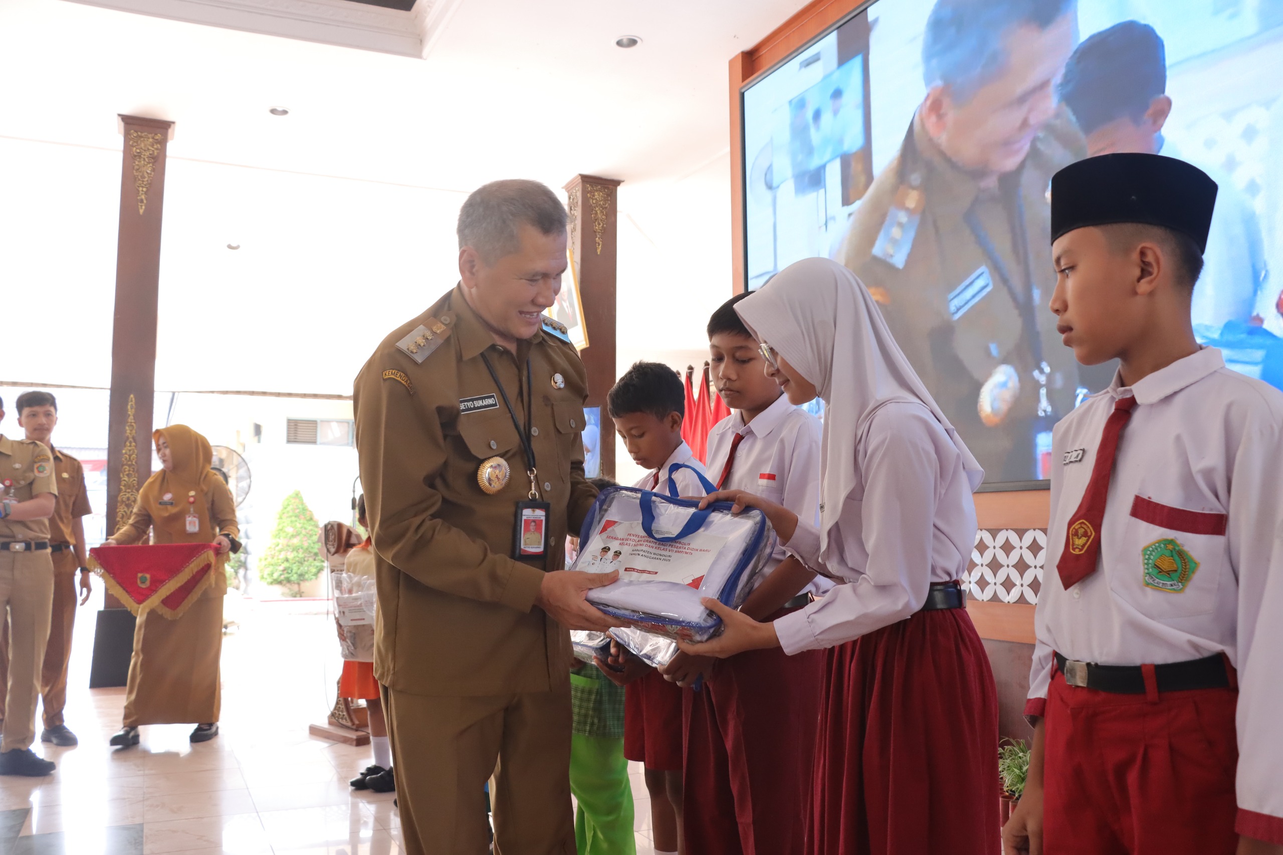 Bupati Wonogiri Setyo Sukarno secara simbolis menyerahkan seragam gratis kepada perwakilan siswa di pendapa Rumah Dinas Bupati Wonogiri, Selasa (16/9/2025).