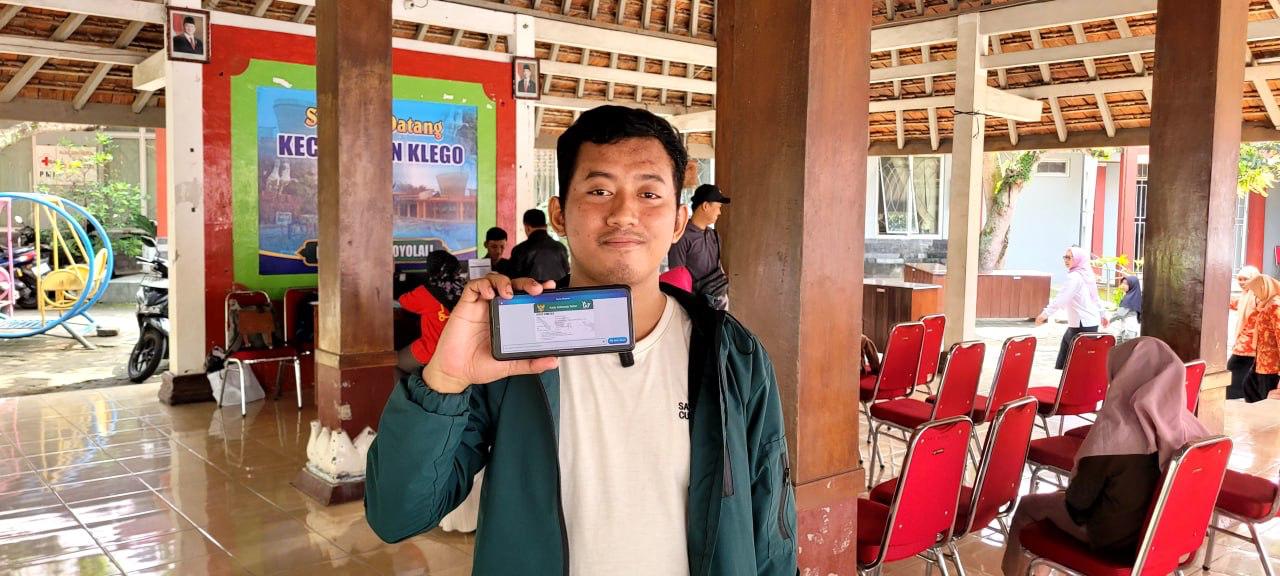 Peserta JKN asal Boyolali Aldianto saat menunjukan kartu kepesertaan BPJS Kesehatan saat BPJS dalam Mobile Customer Service (MCS) di Kecamatan Klego.