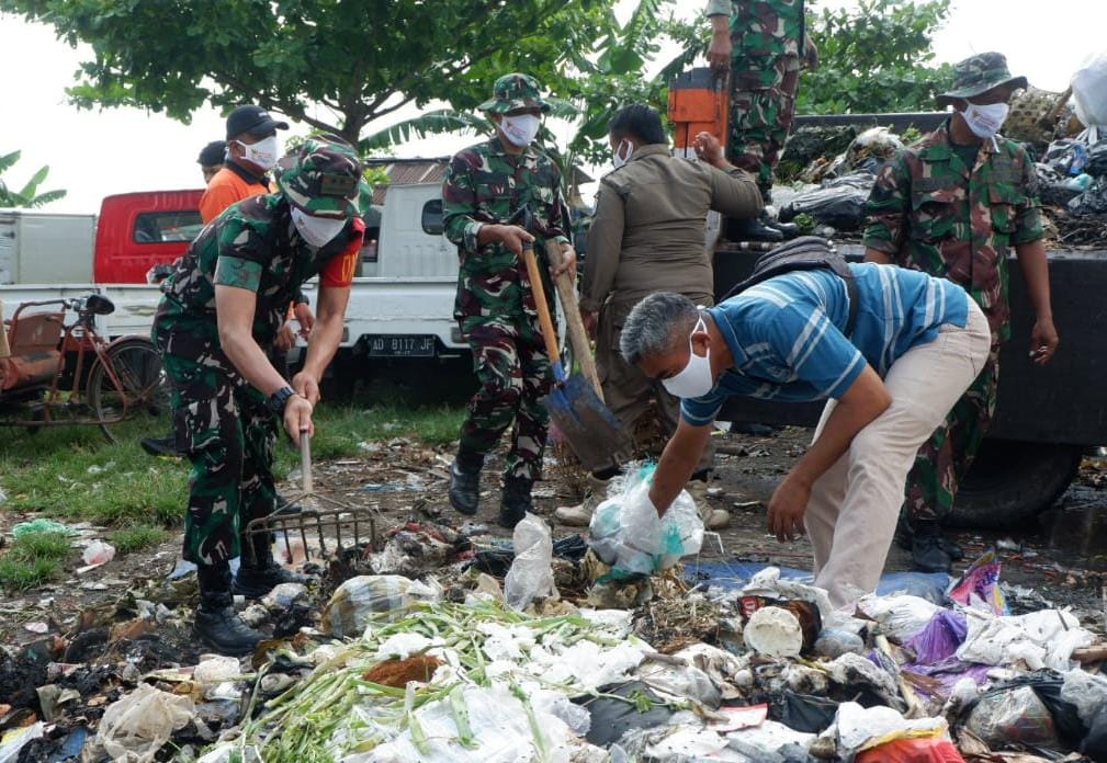 Anggota Kodim 0727 Karanganyar bersama relawan gabungan membersihkan sampah di Pasar Nglano, Tasikmadu, Karanganyar. (Rudi Hartono/Radar Solo)