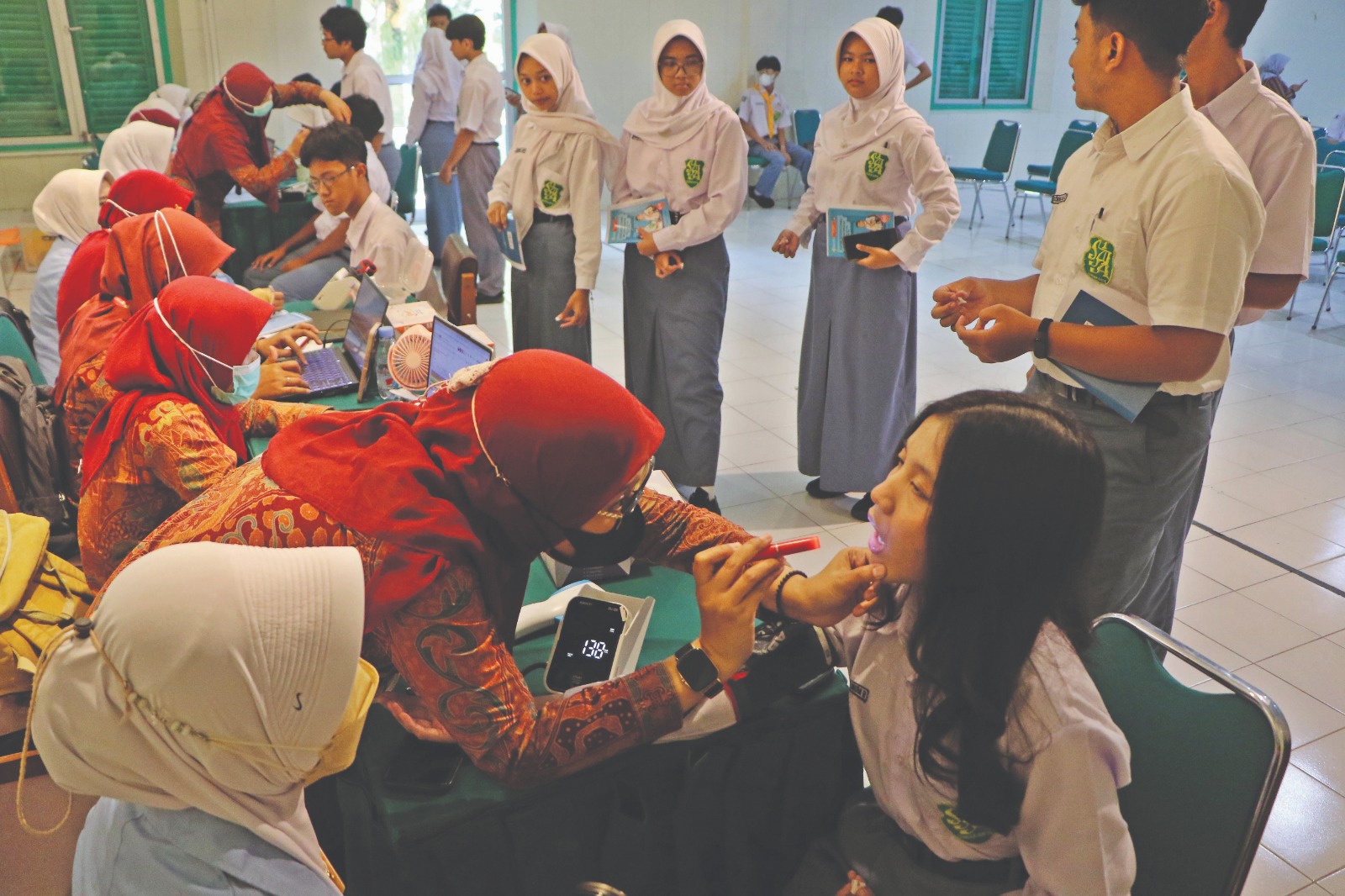 Siswa SMAN 1 Solo menjalani pemeriksaan kesehatan gratis, dipandu tenaga kesehatan dari Puskesmas Gilingan di sekolah setempat, Selasa (23/9).