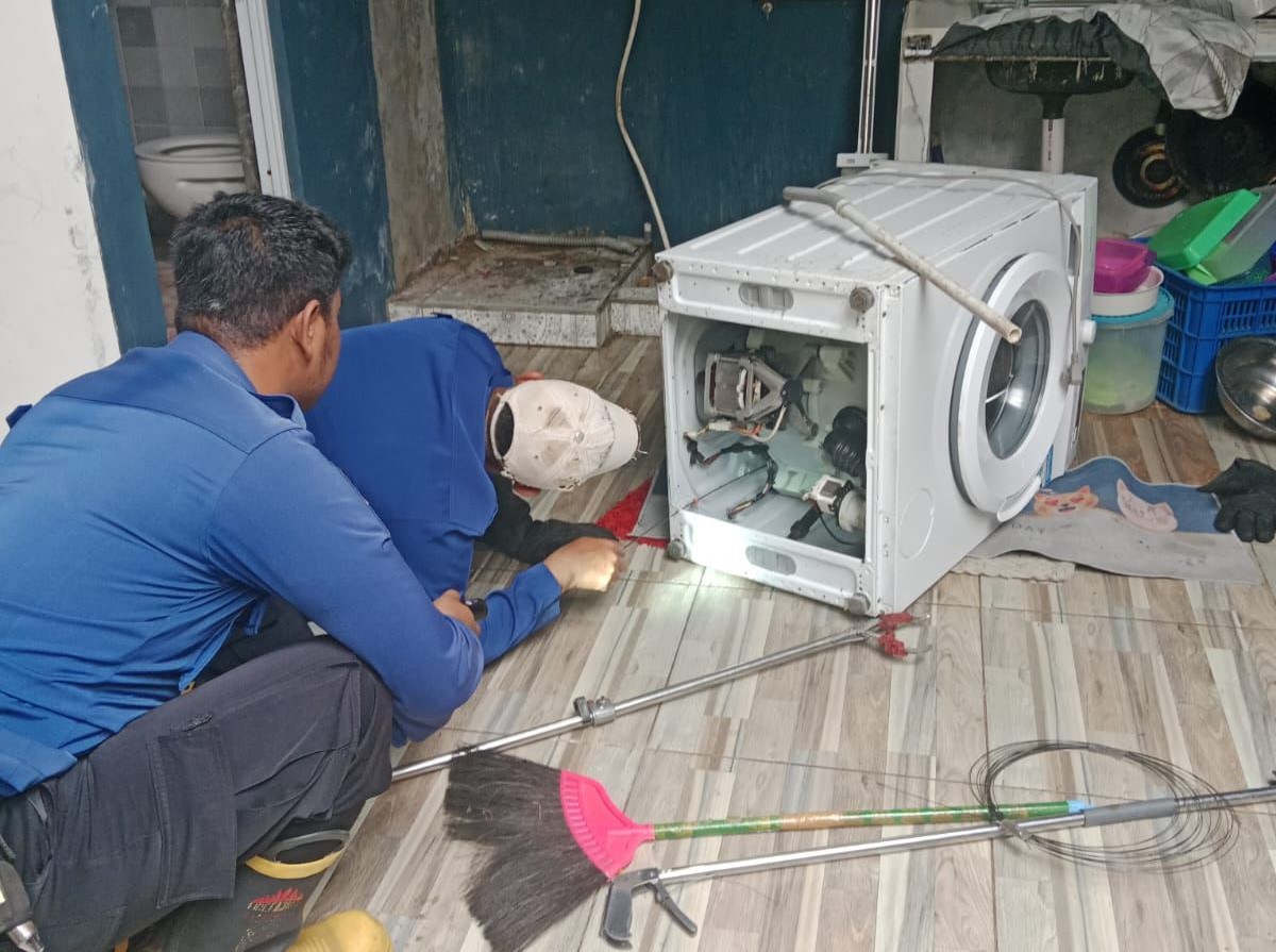 Personel Damkar Boyolali mengevakuasi ular dari dalam mesin cuci milik warga.