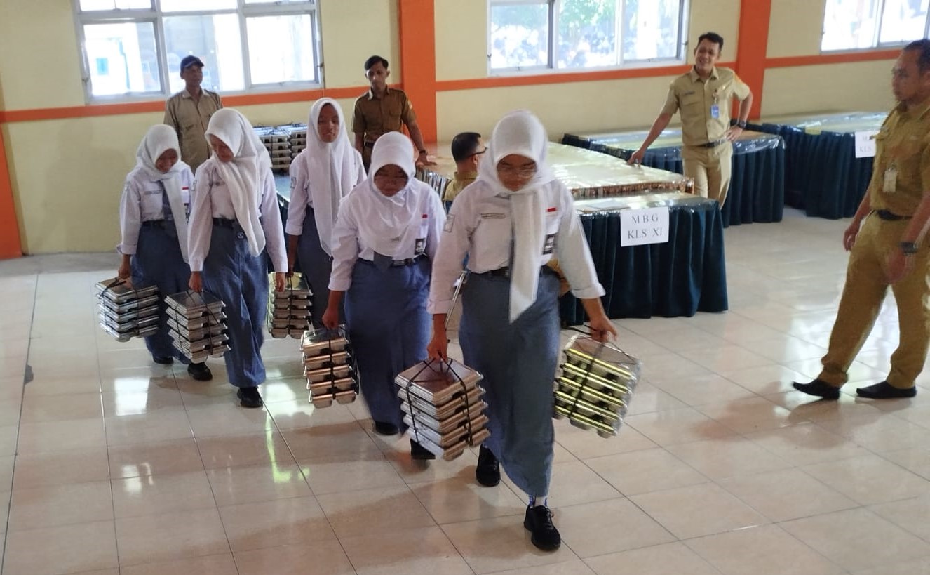 Siswa SMAN 2 Wonogiri membawa menu MBG untuk dibagikan ke teman sekelas, Senin (23/9/2025)