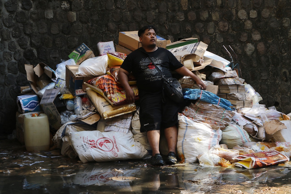 Pedagang Pasar Kota Wonogiri tampak kelelahan setelah mengevakuasi barang dagangan dari amukan api, Senin (6/10/2025).