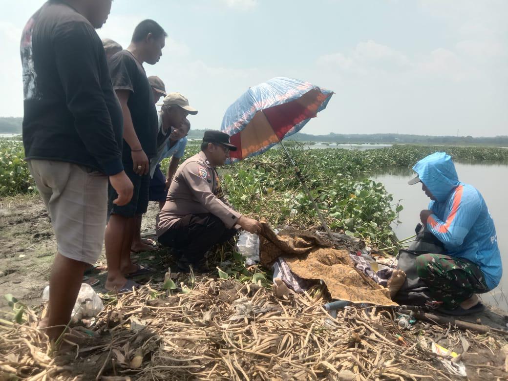 Polisi dan warga memeriksa kondisi Sukatmin, 69, warga Desa Cemani, Kecamatan Grogol, Sukoharjo yang meninggal di Waduk Cengklik.