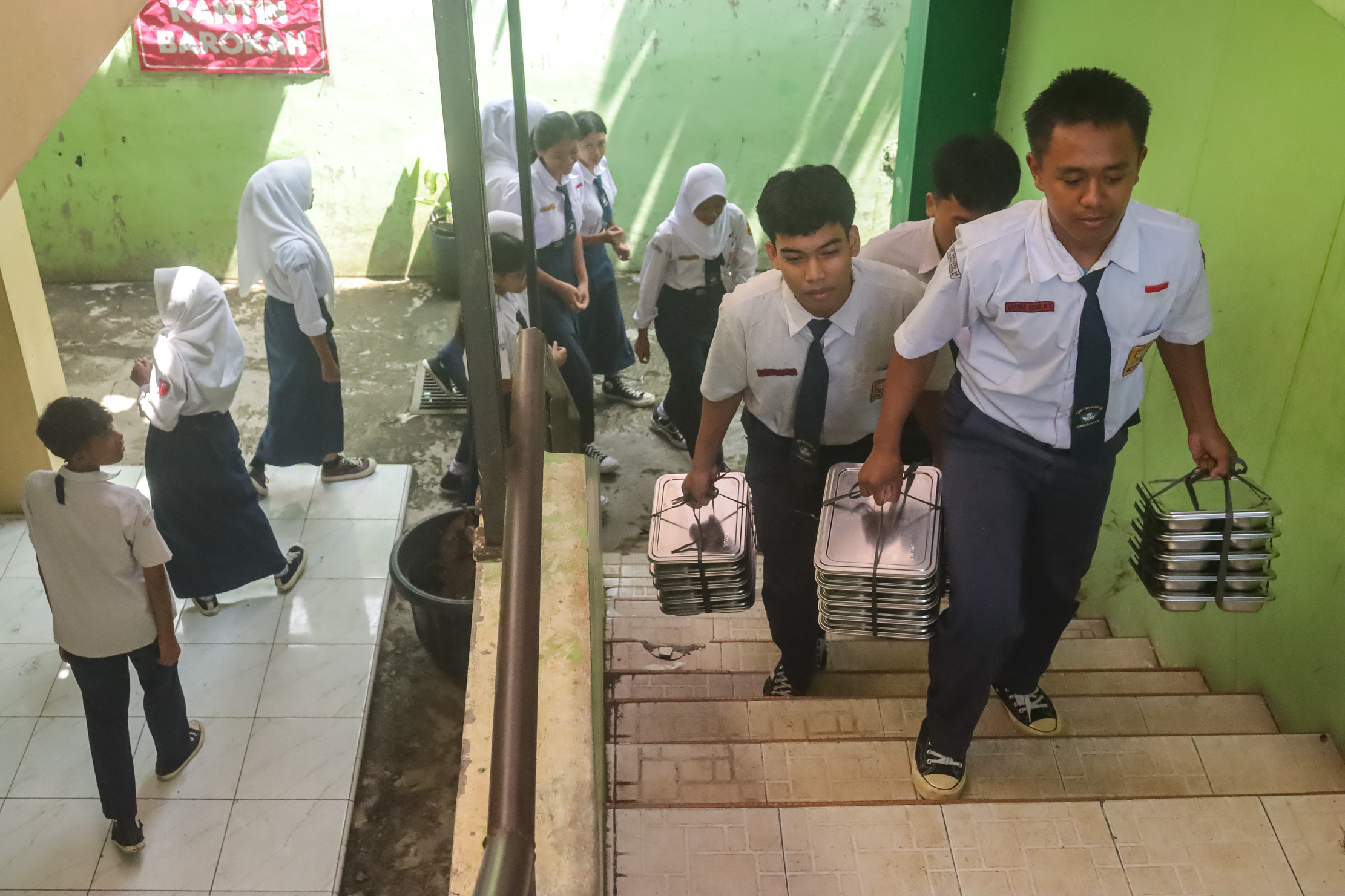 KOMPAK: Siswa kelas 9 di SMP N 14 Surakarta saat membawa makan bergizi gratis ke dalam kelas.