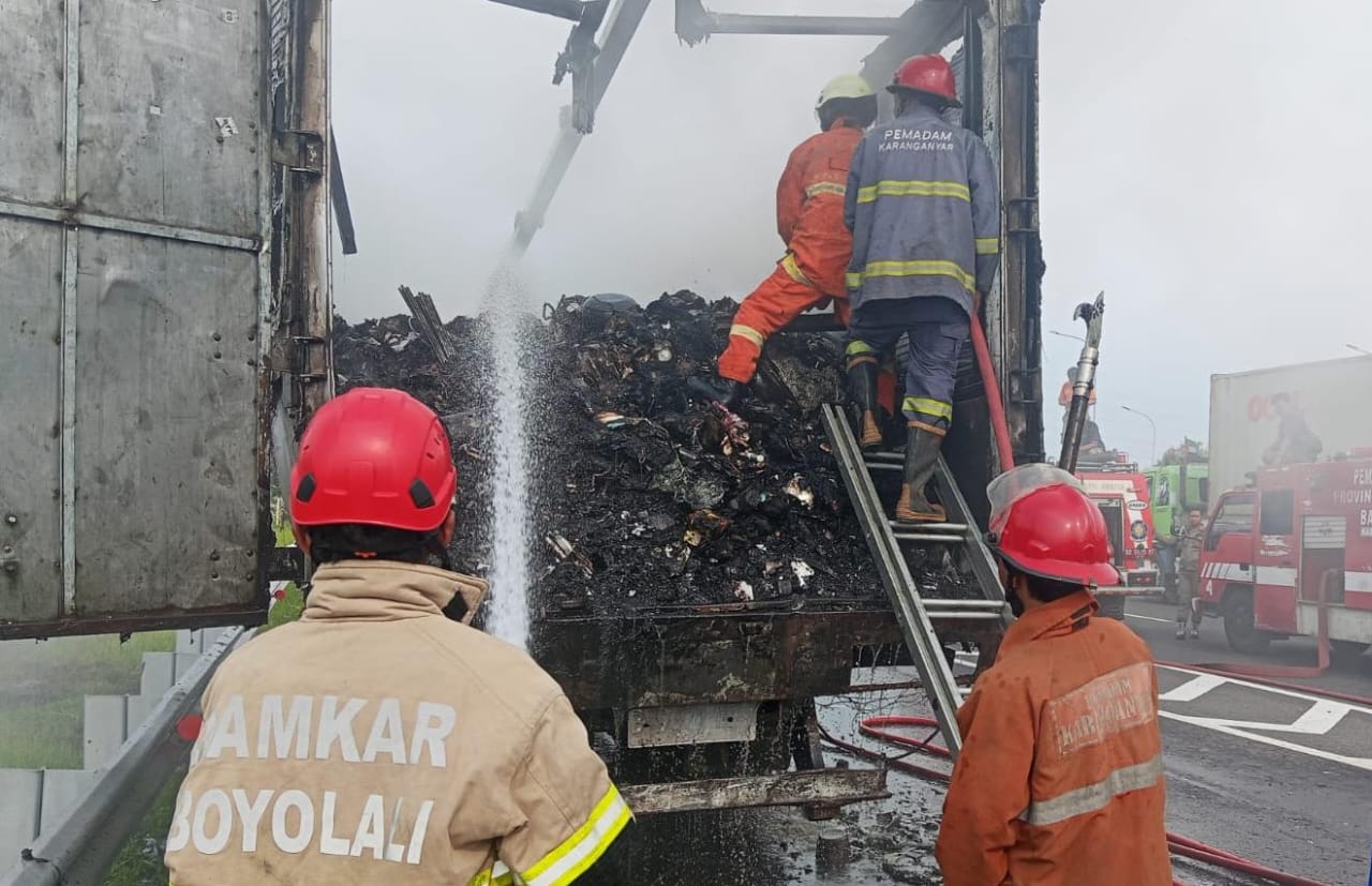 Tim damkar gabungan berupaya padamkan api di sebuah truk kontainer paket yang terbakar di Jalan Tol Solo-Sragen, Gondangrejo, Karanganyar, Jumat (17/10/2025). (Rudi Hartono/Radar Solo)
