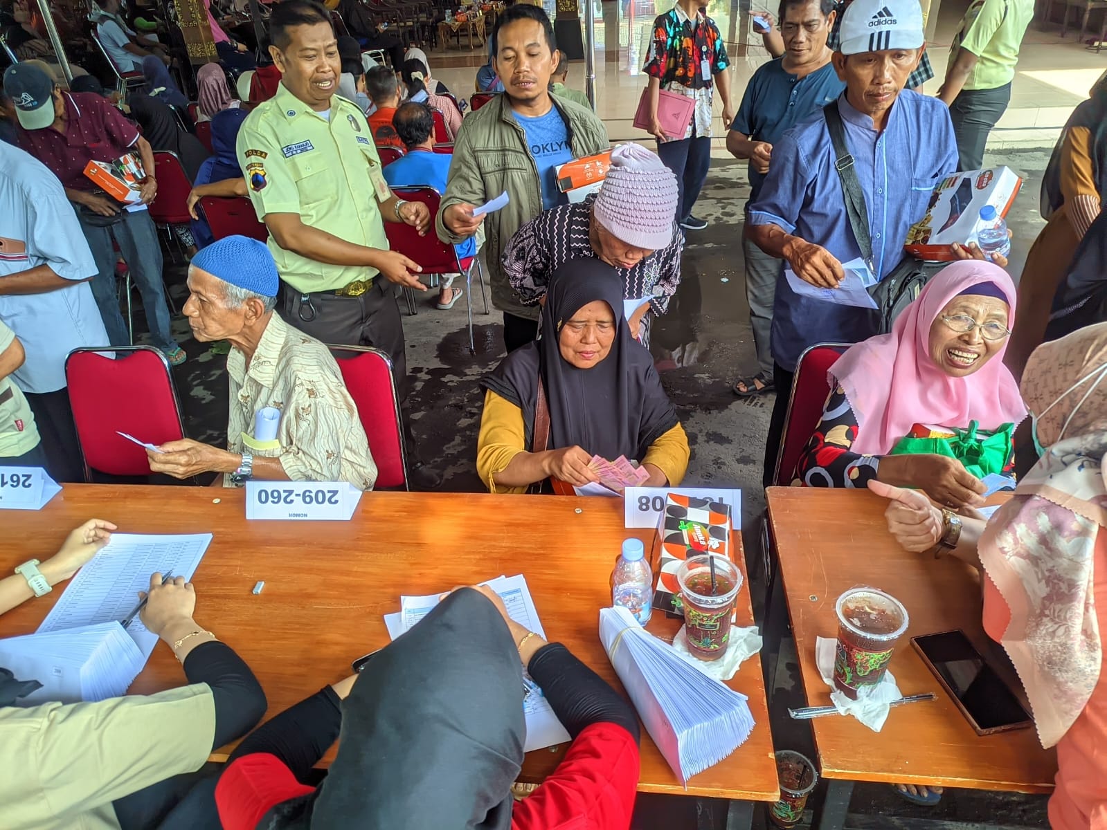 Pedagang Pasar Kota Wonogiri menerima bansos berupa uang tunai Rp 1 juta di area pendapa Rumah Dinas Bupati Wonogiri, Minggu (19/10/2025).