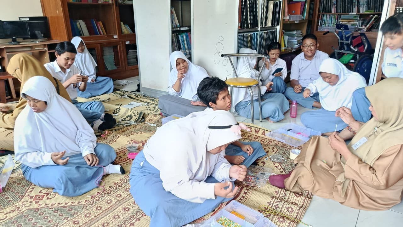 Siswa SMA di SLBN Solo praktik menganyam manik-manik bersama guru di sekolah setempat, Senin (20/10).