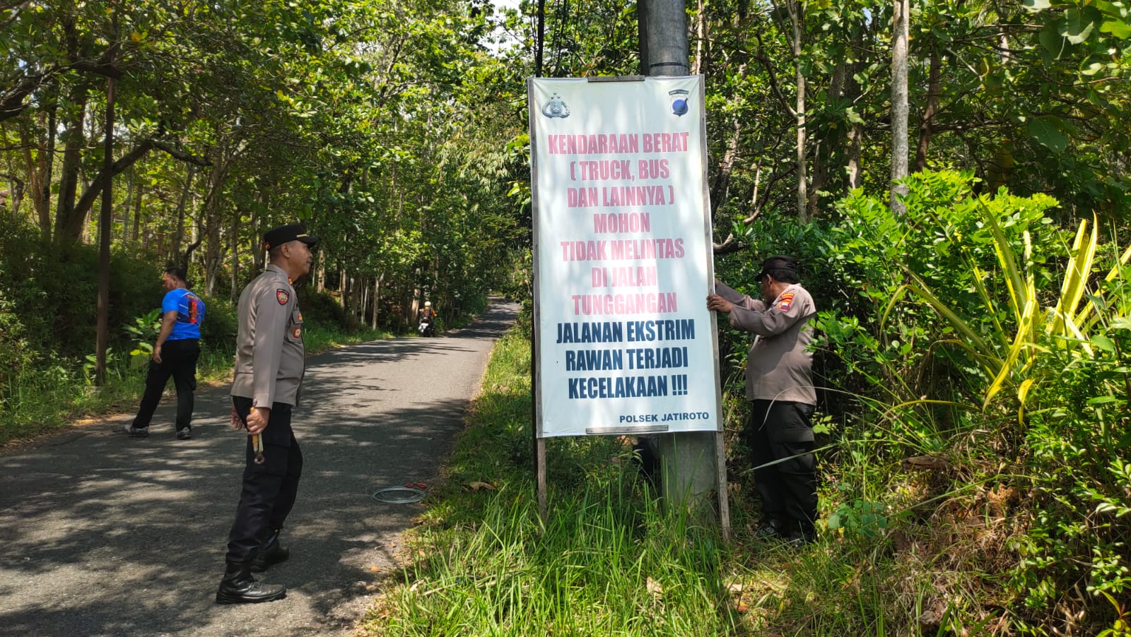 Polisi memasang banner berisi larangan kendaraan berat melintasi jalur Tunggangan di wilayah Kecamatan Jatiroto, Jumat (17/10/2025).