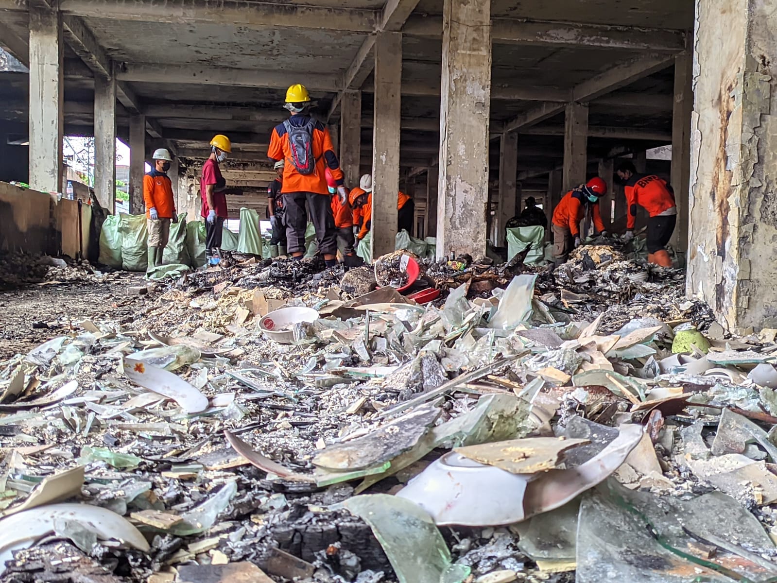 Petugas membersihkan sisa-sisa kebakaran di Pasar Kota Wonogiri, Selasa (21/10/2025). Banyak terdapat pecahan kaca yang membahayakan.