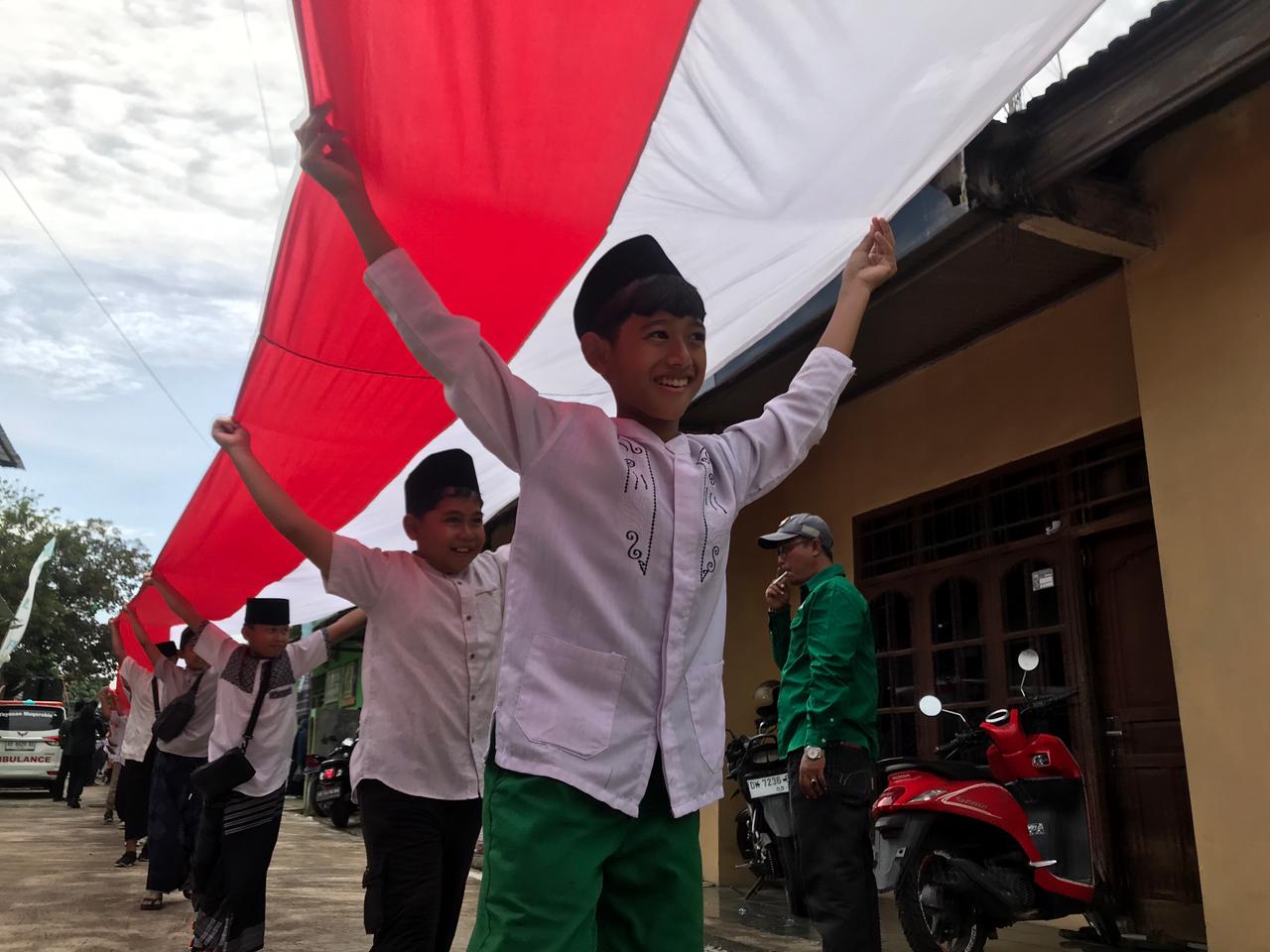 Ribuan santri di Andong Boyolali kirabkan bendera Merah Putih sepanjang 1.000 meter untuk peringati Hari Santri Nasional 2025.