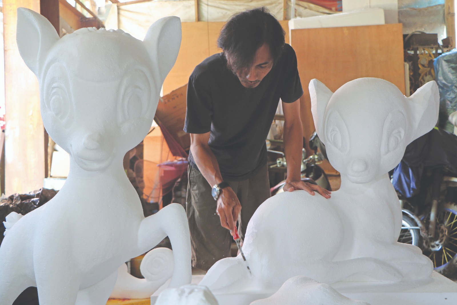 KREATIF: Yudi saat memotong styrofoam yang disulap jadi patung karakter kartun.