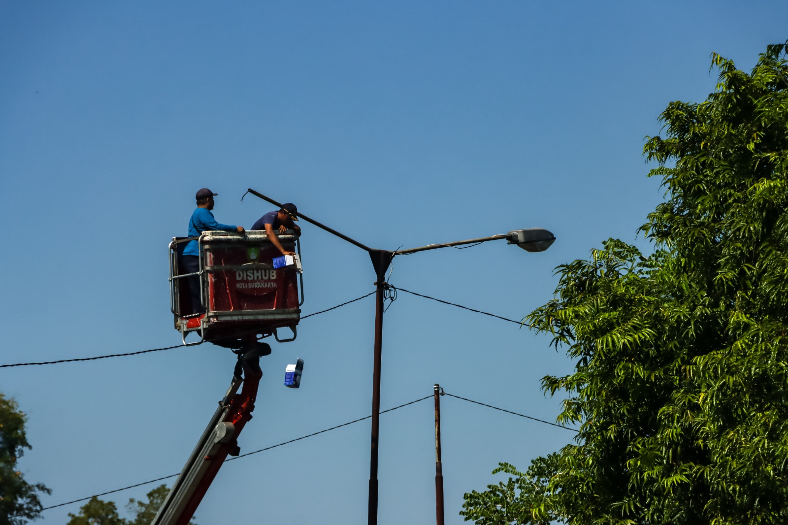 Petugas Dinas Perhubungan (Dishub) Kota Solo tengah memperbaiki PJU.