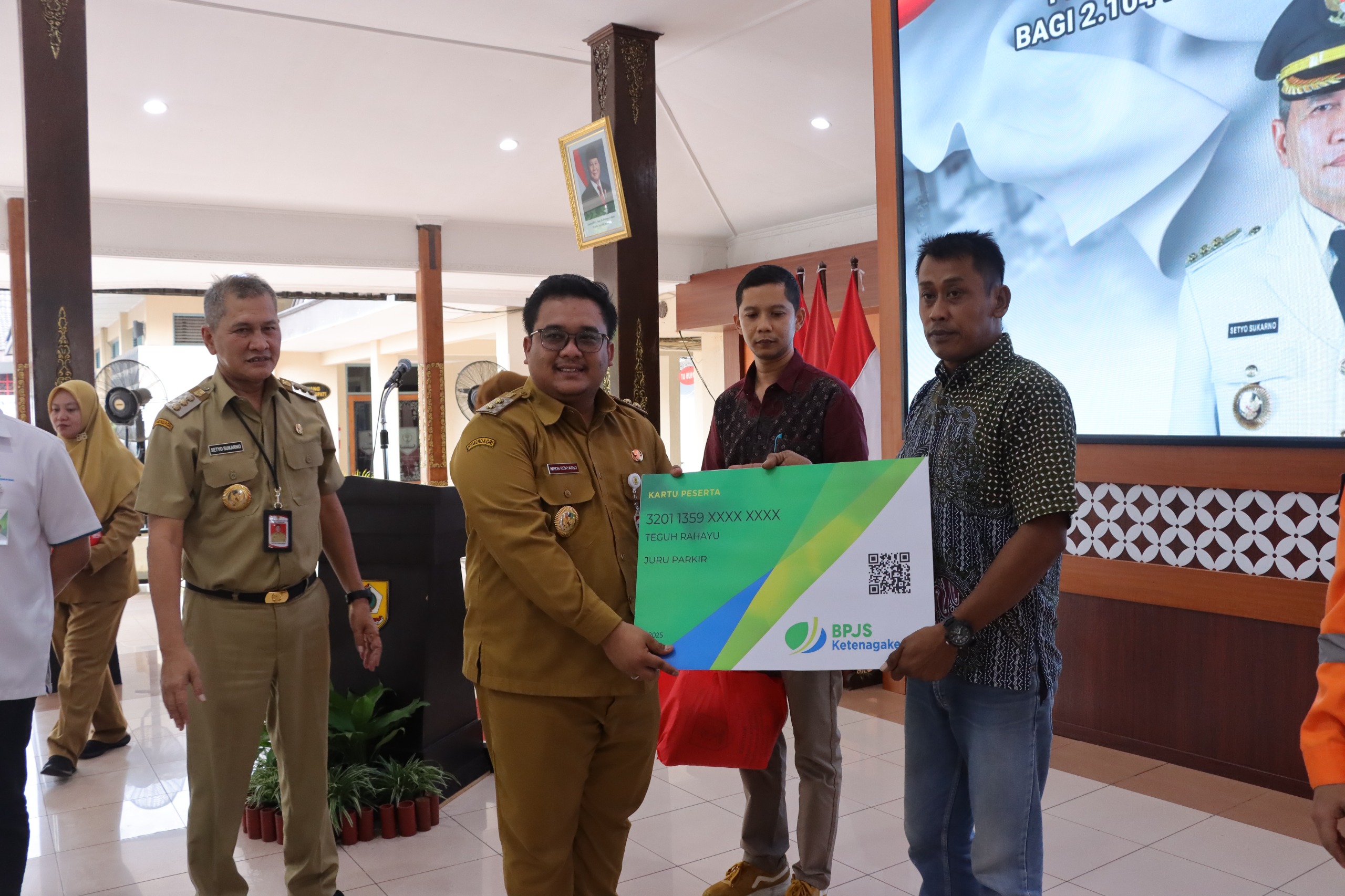 Wabup Wonogiri Imron Rizkyarno serahkan secara simbolis kartu peserta BPJS Ketenagakerjaan kepada juru parkir di pendapa Rumah Dinas Bupati Wonogiri.
