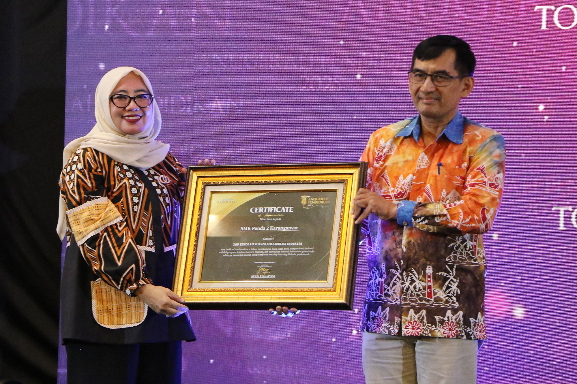 Kepala SMK Penda 2 Karanganyar Aris Sukarno (kanan) menerima penghargaan kategori Top Sekolah Vokasi Kolaborasi Industri di Anugerah Pendidikan Radar Solo 2025.