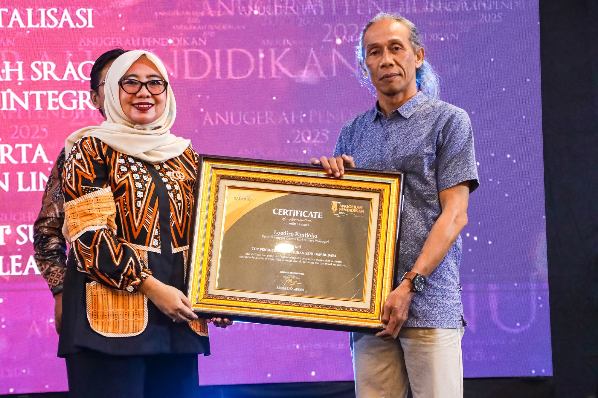 TERUS BERKARYA: Loediro Pantjoko menerima penghargaan dari Direktur Jawa Pos Radar Solo Resita Rika Aryani. (M Ihsan/Radar Solo)
