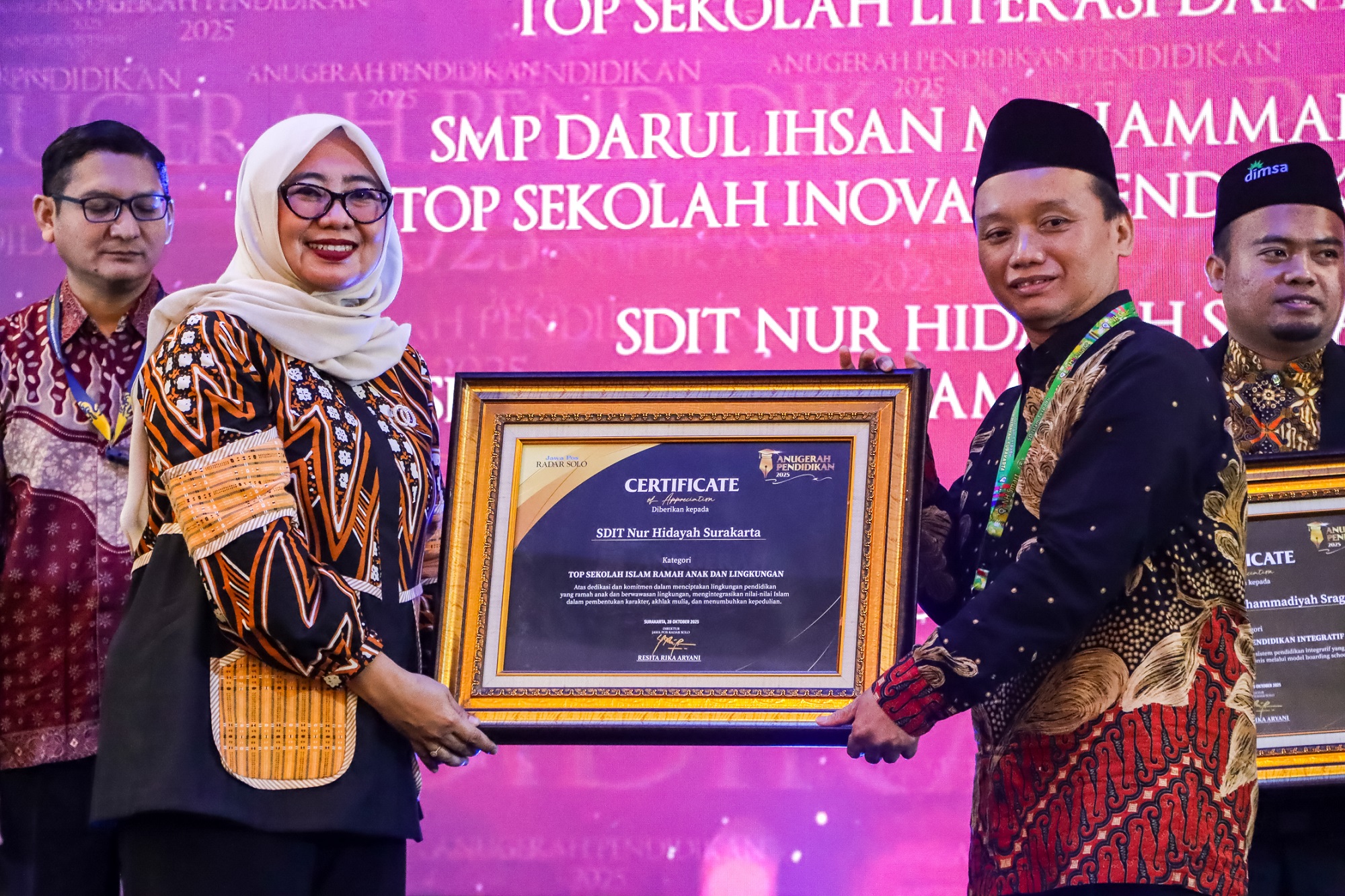 Kepala SDIT Nur Hidayah Surakarta Eko Sugiyanto (kanan) meraih penghargaan kategori Top Sekolah Islam Ramah Anak dan Lingkungan di Anugerah Pendidikan Radar Solo 2025, Selasa (28/10/2025). (M.Ihsan)