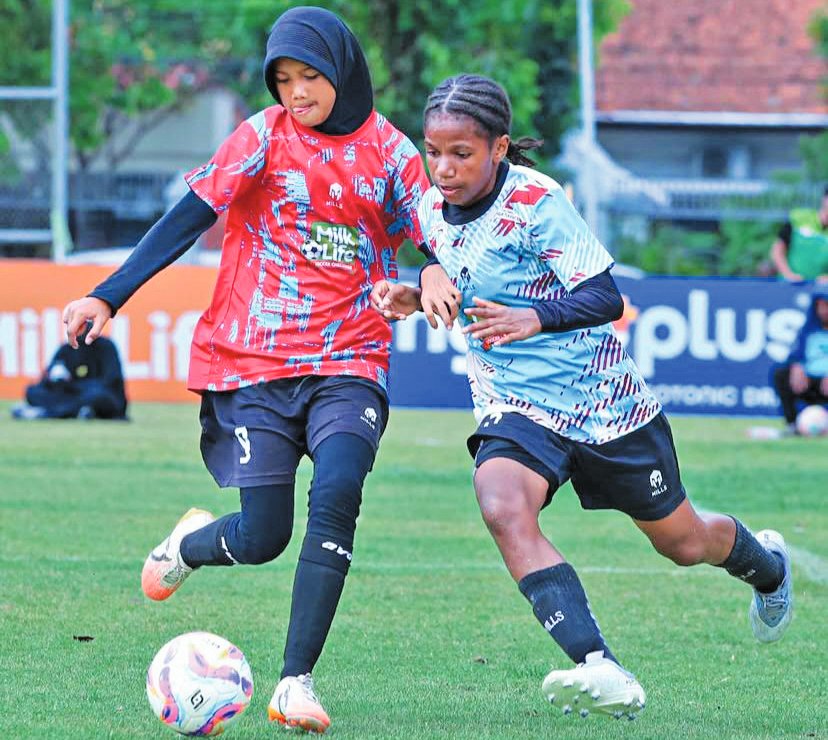 BERJIBAKU: Pemain SD Kristen Manahan Ika Wonda (jersey biru) sedang berhadapan dengan pemain MIN 9 Sragen di partai final KU 12 MilkLife Soccer Challenge Seri 1 2025