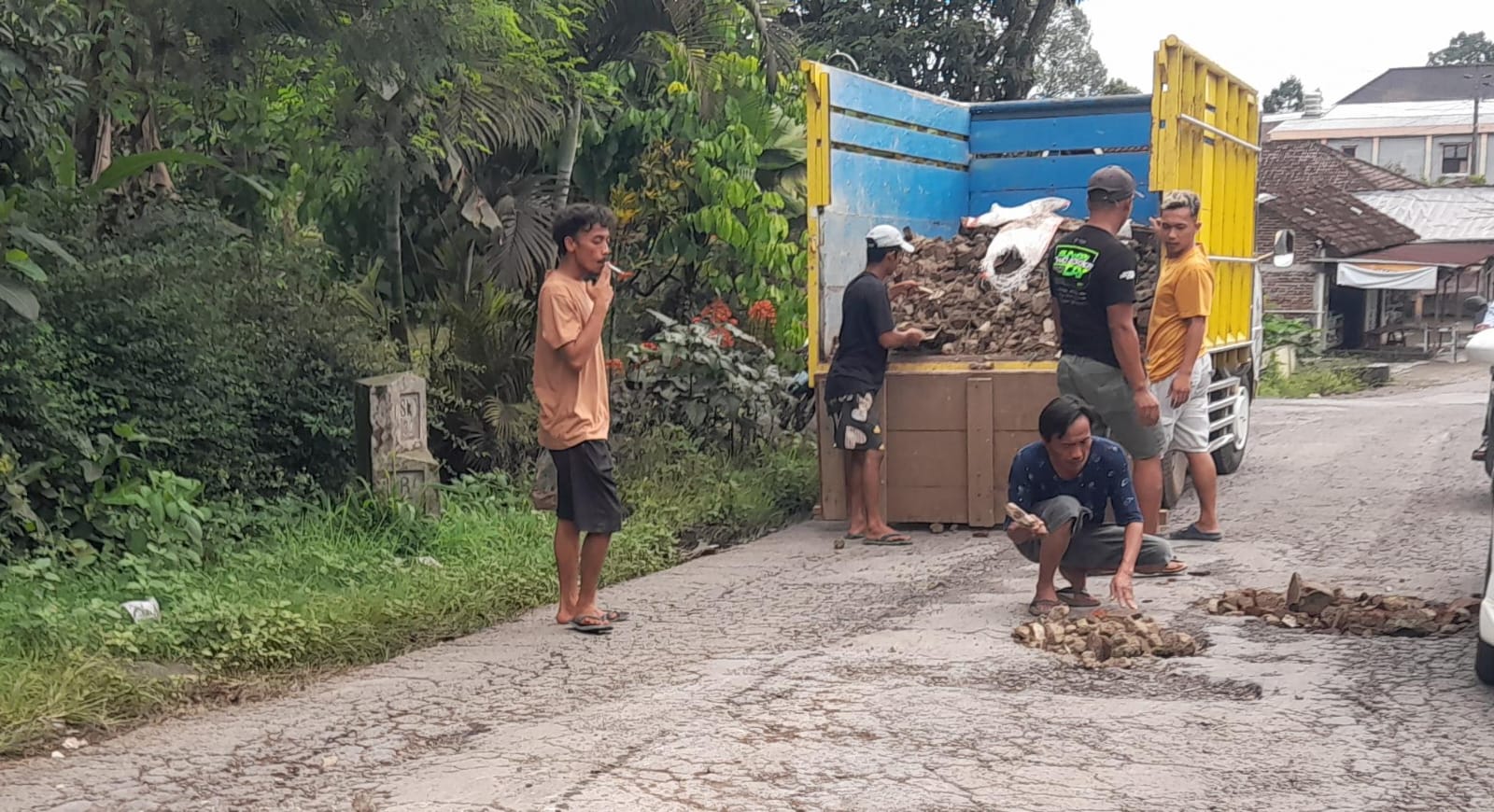 Komunitas Driver Tangki Kemuning (DTK) menutup lubang jalan Karangpandan-Ngargoyoso, yang merupakan jalur wisata penting di Karanganyar, Minggu (2/11/2025). (Rudi Hartono/Radar Solo)