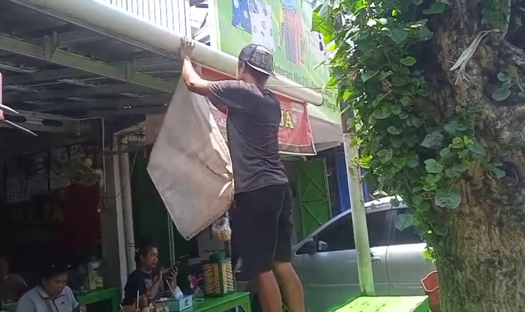 Pencopotan spanduk di sebuah warung bakso di Kota Solo.