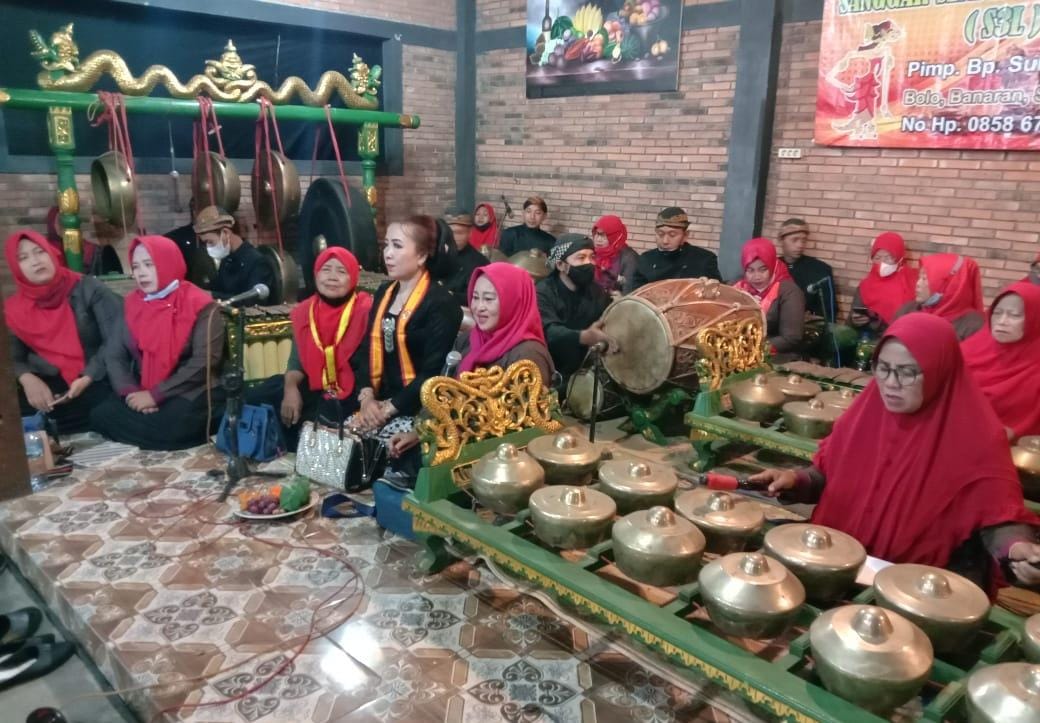 Ilustrasi ibu-ibu menabuh seperangkat gamelan.