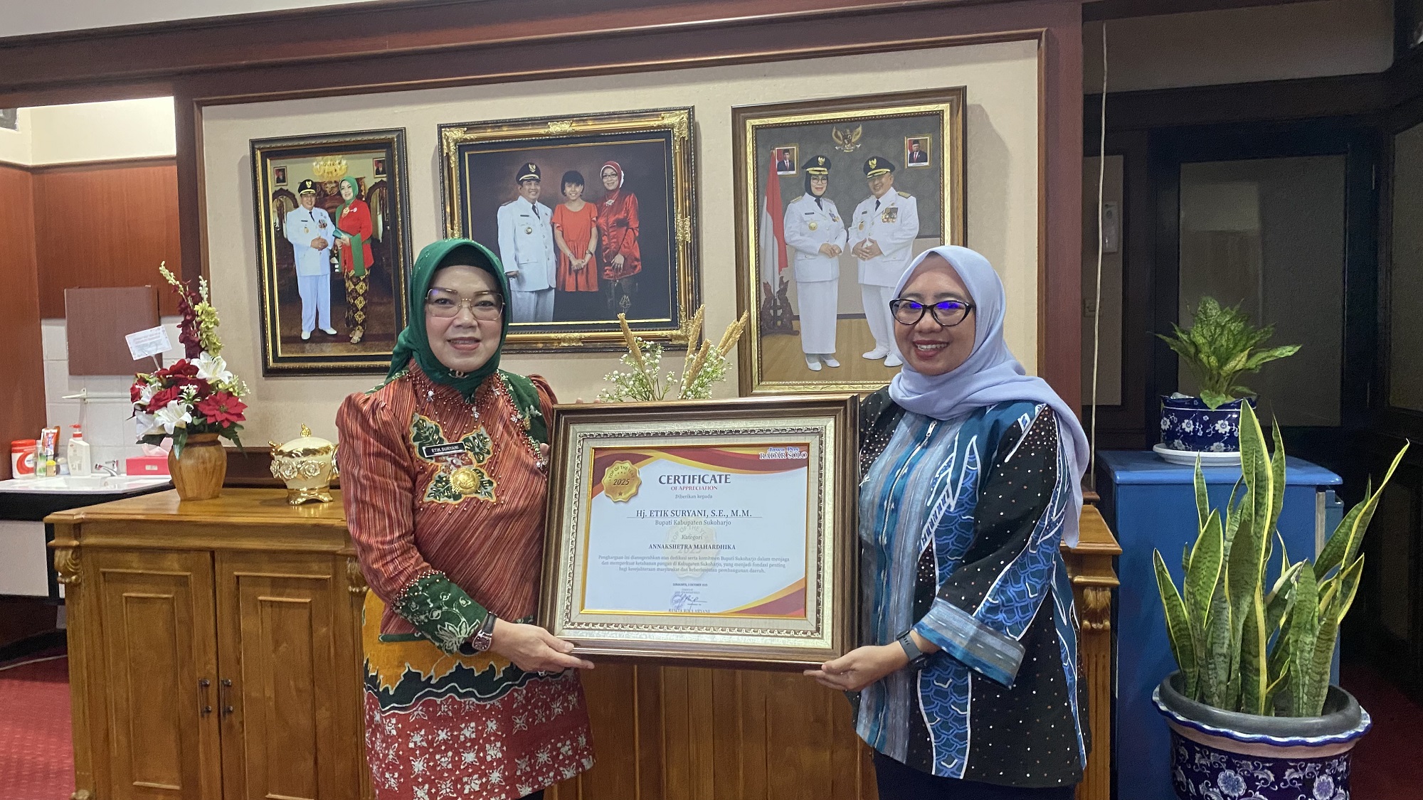 Direktur Jawa Pos Radar Solo Resita Rika Aryani serahkan penghargaan Top of The Year 2025 kepada Bupati Sukoharjo Etik Suryani. (Tri Wahyu Cahyono/Radar Solo)