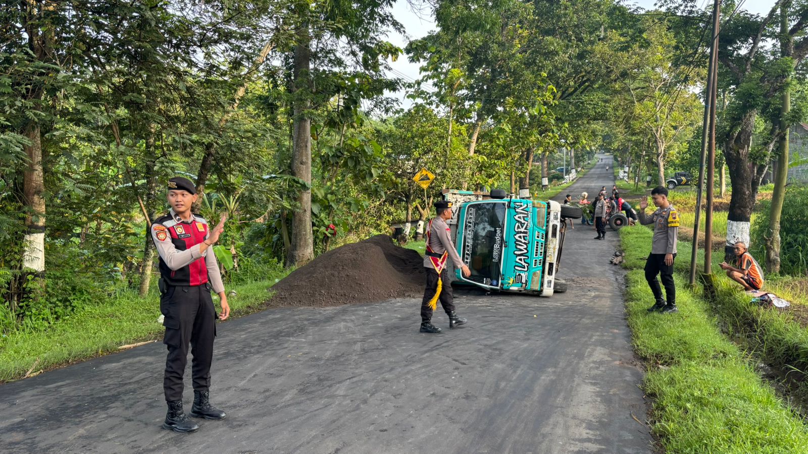 Ban Belakang Pecah, Truk Pengangkut Pasir Terguling Tumpahkan Muatan ke Jalan