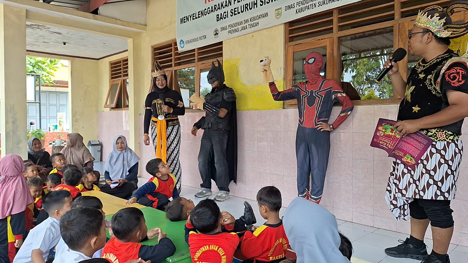 Sejumlah siswa PAUD dan SD di Kelurahan Begajah, Kecamatan/Kabupaten Sukoharjo mendengarkan dongeng yang disampaikan empat tokoh superhero, Senin (17/11).