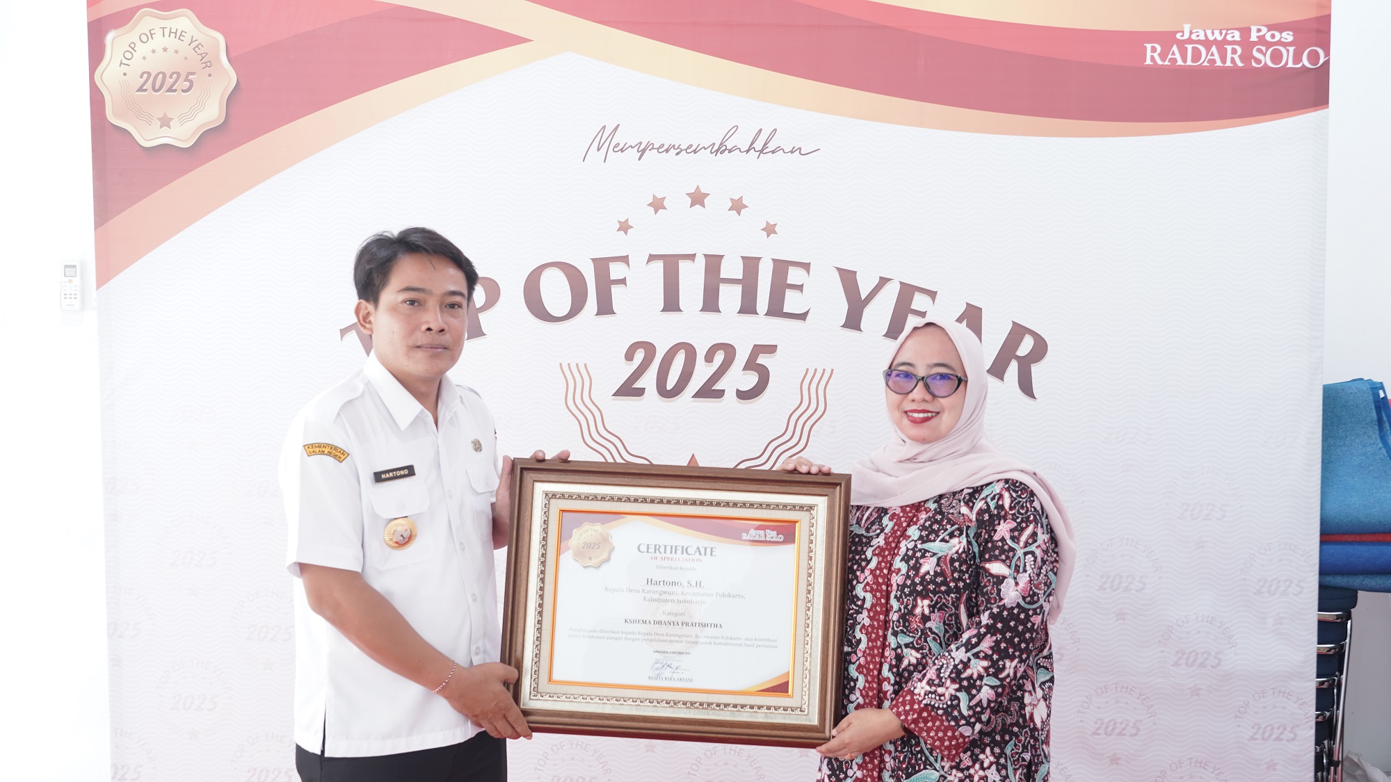 Kades Karangwuni Hartono menerima penghargaan Top of The Year 2025 dari Direktur Jawa Pos Radar Solo Resita Rika Aryani. (Tri Wahyu Cahyono/Radar Solo)