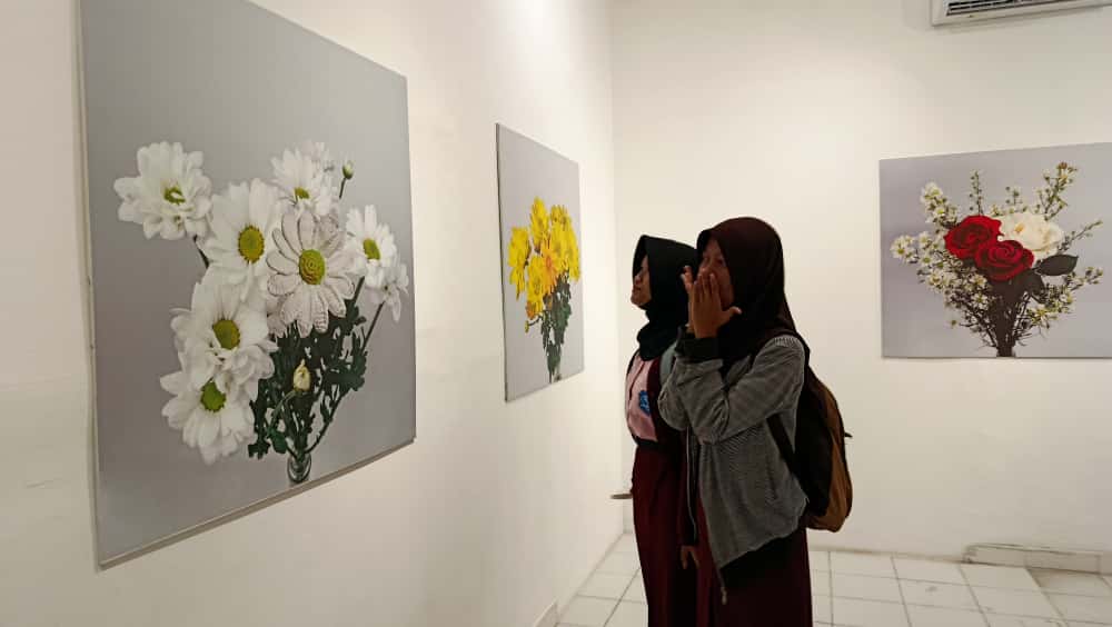 Siswa SMKN 8 Solo melihat karya fotografi dalam pameran Stories of Me di Nalla Kafe Solo, Kamis (20/11).